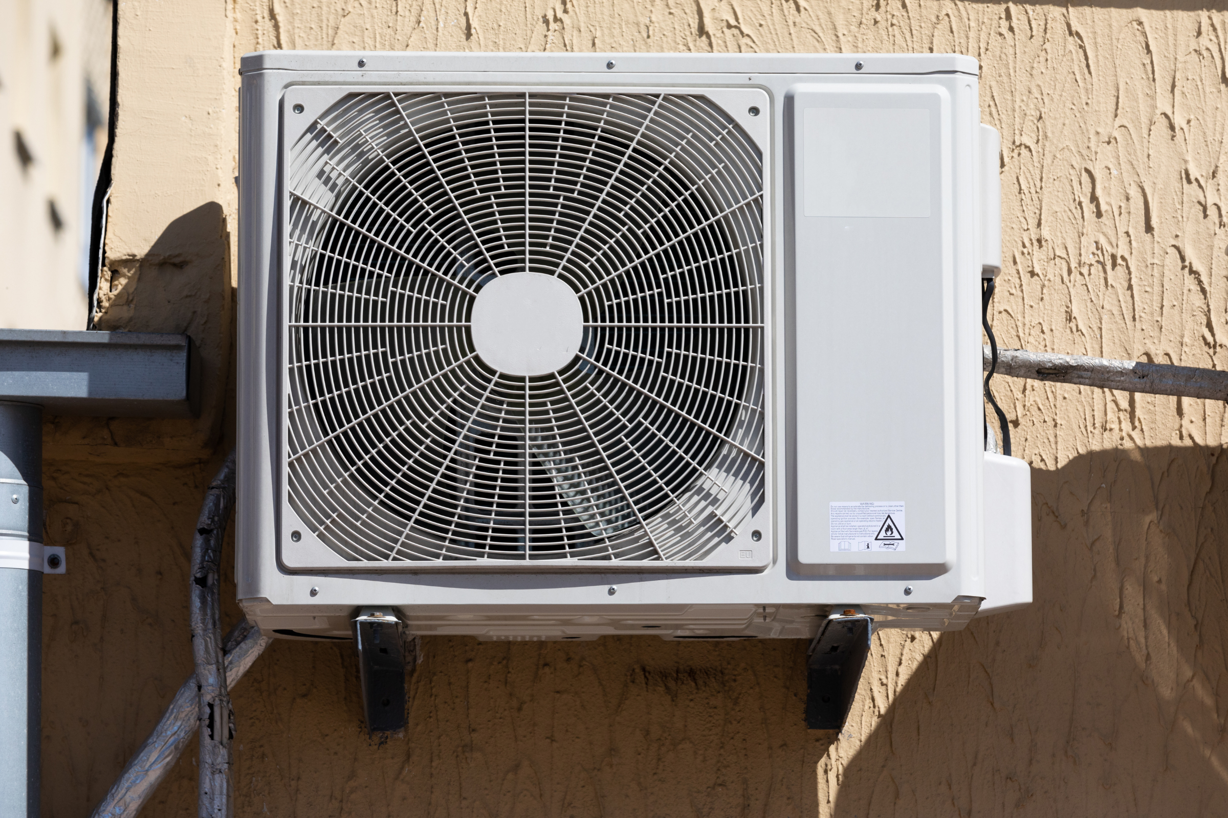Wall mounted outdoor air conditioning condenser installed at a Carmel Valley California residence