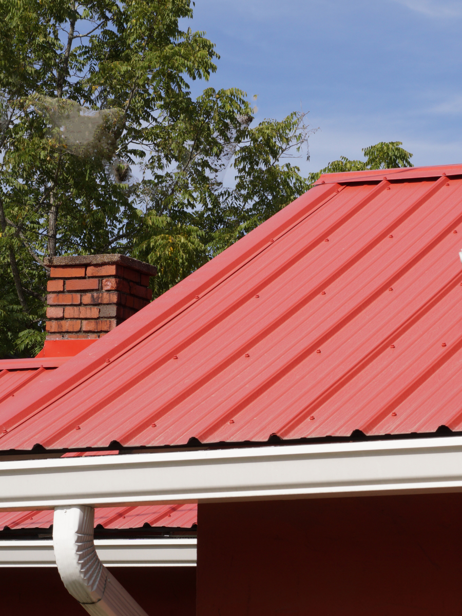 Red metal roofing system with gutters and downspouts