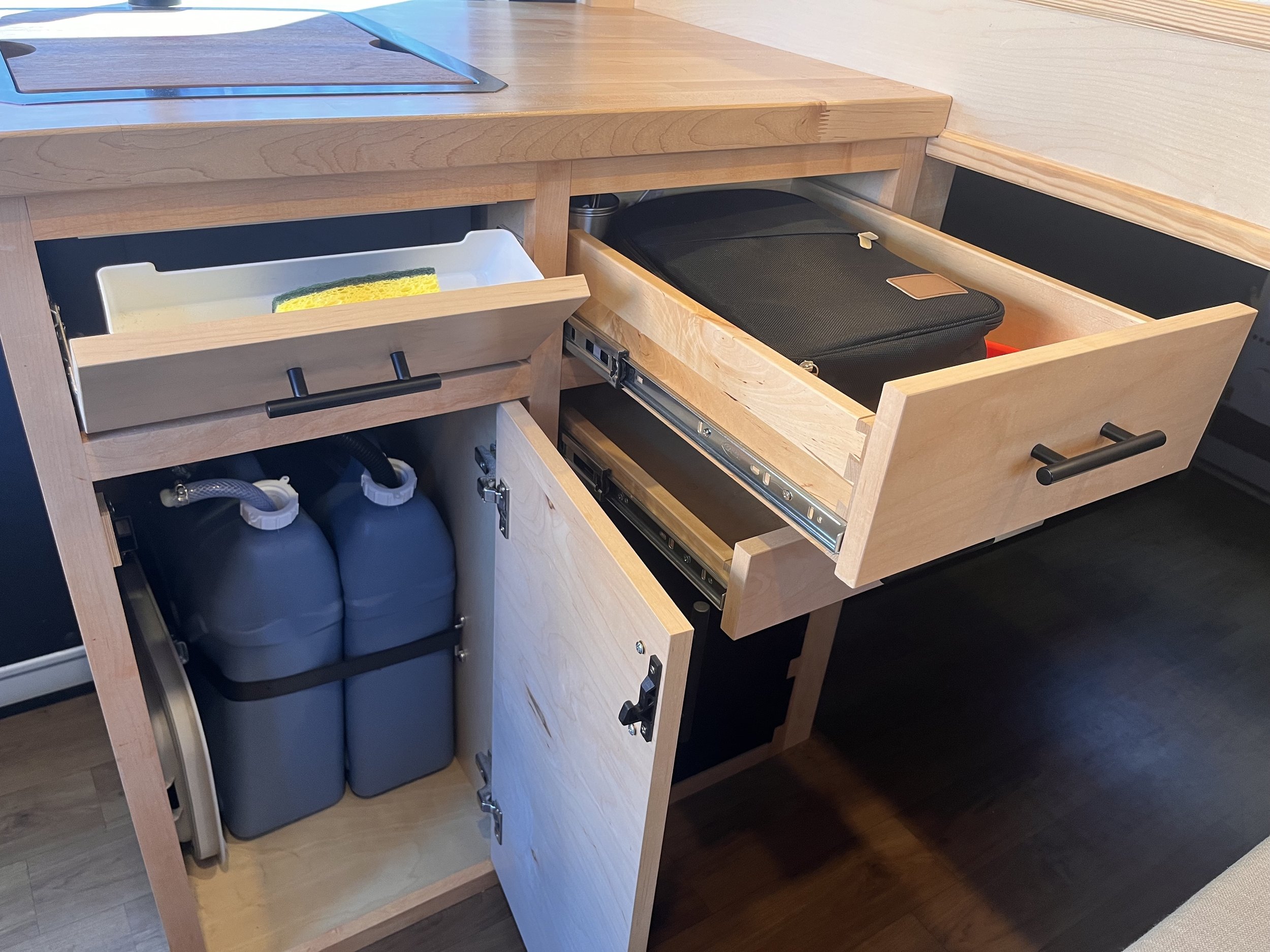 Includes tip-out sponge tray, utensil and utility drawers, and 6-gallon fresh and grey water tanks