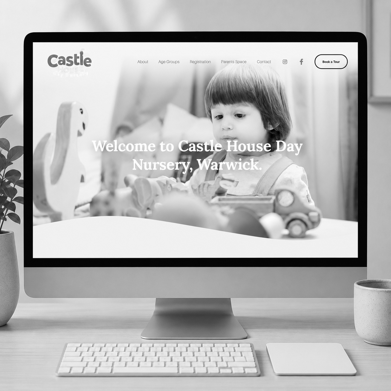 Computer screen displaying the website for Castle House Day Nursery in Warwick, featuring a young child playing with toys.