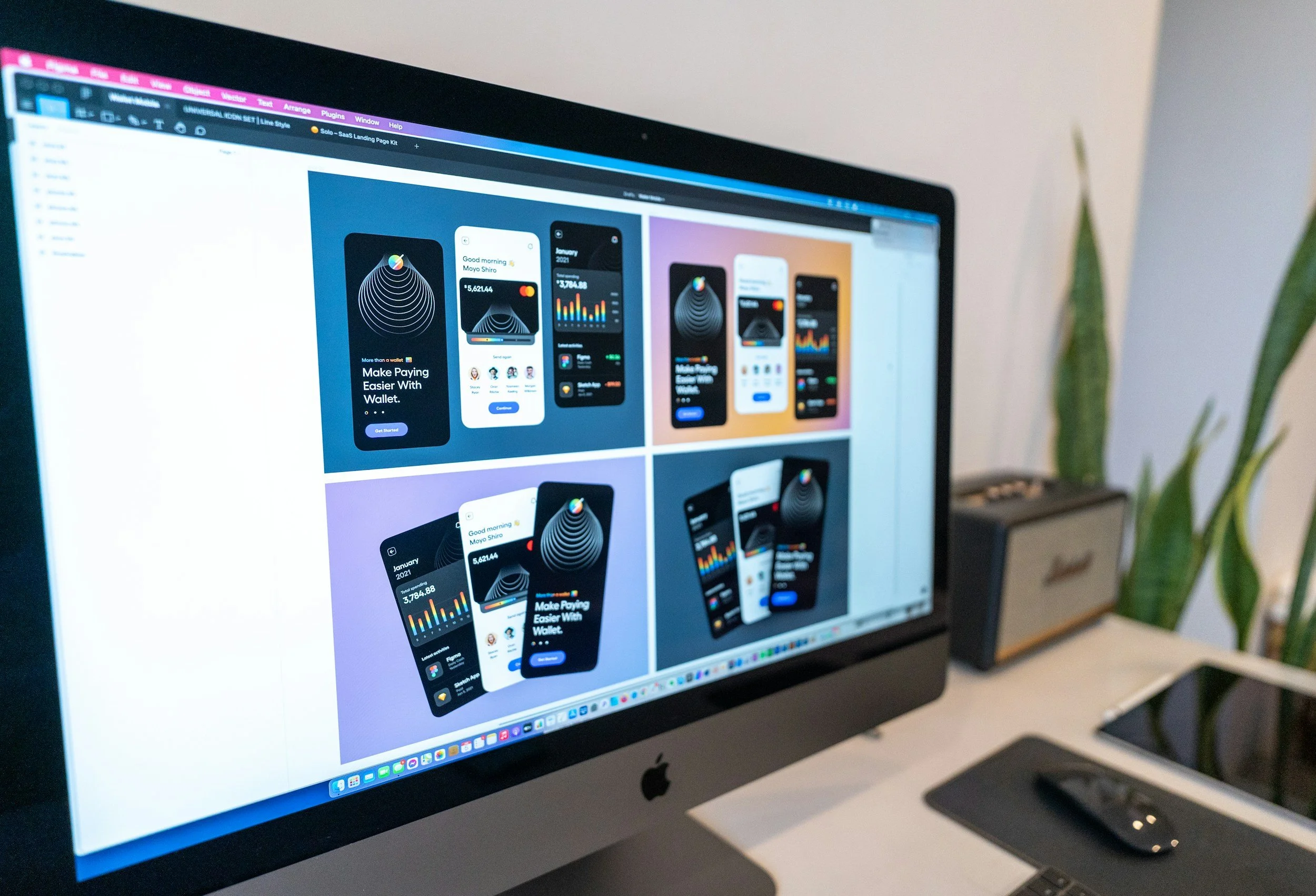 A close-up of an Apple iMac computer screen displaying various website designs or app mockups. The screen shows colorful graphics, charts, and text related to mobile app or website development.