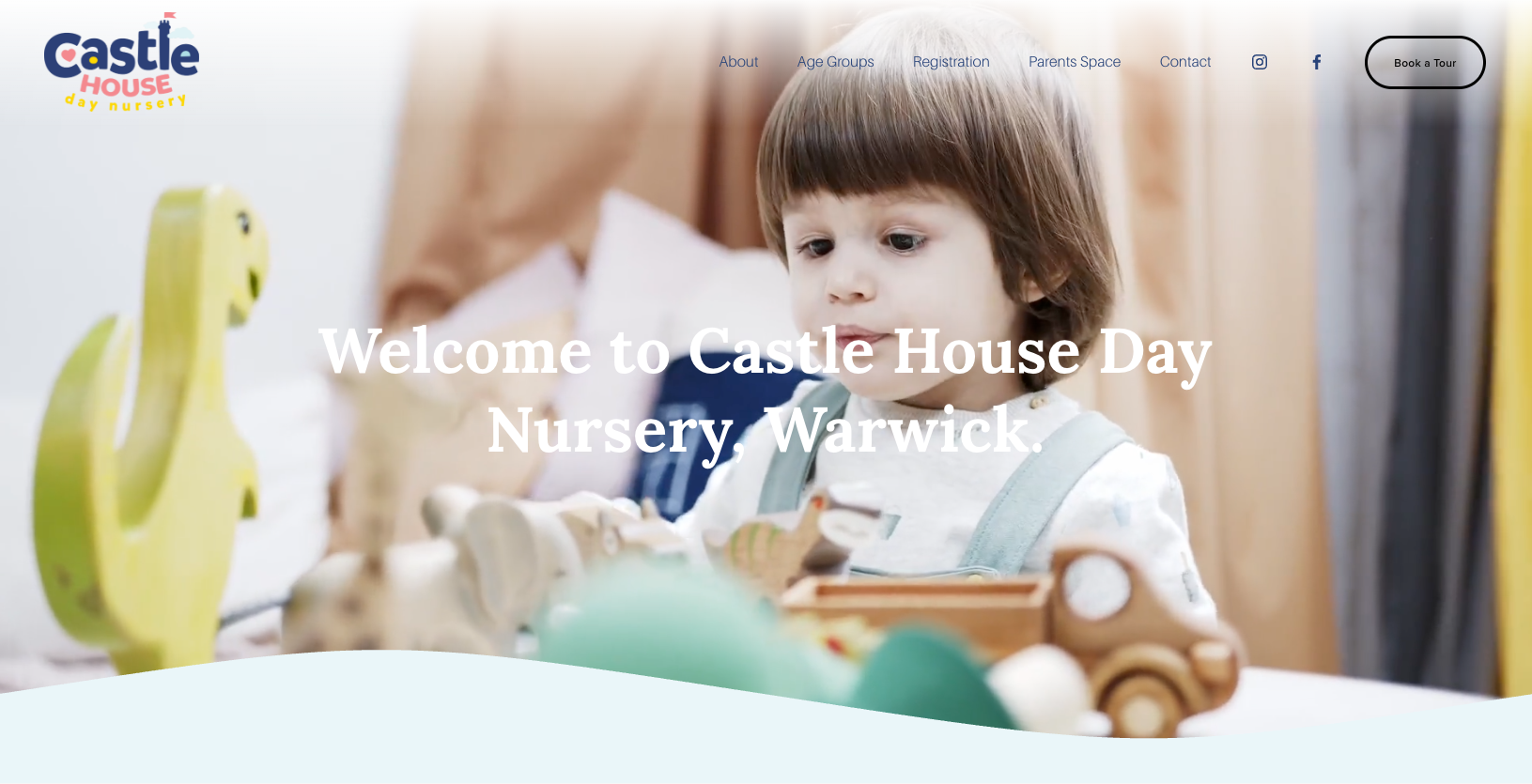 A young child with brown hair looking at wooden toys at Castle House Day Nursery in Warwick.
