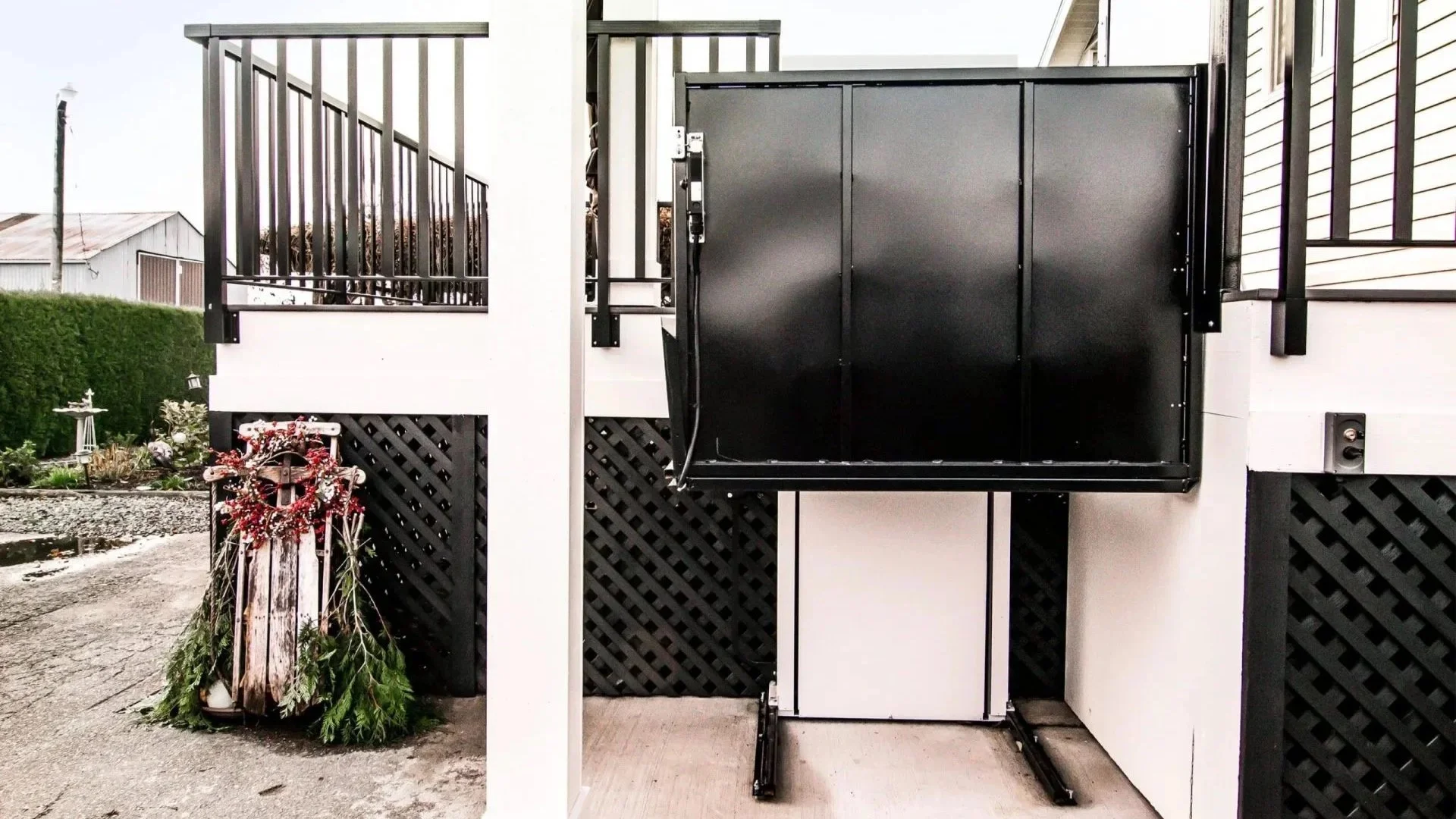 A Butler Mobility RAM Trus-T vertical platform lift moving upward to top of to a residential porch