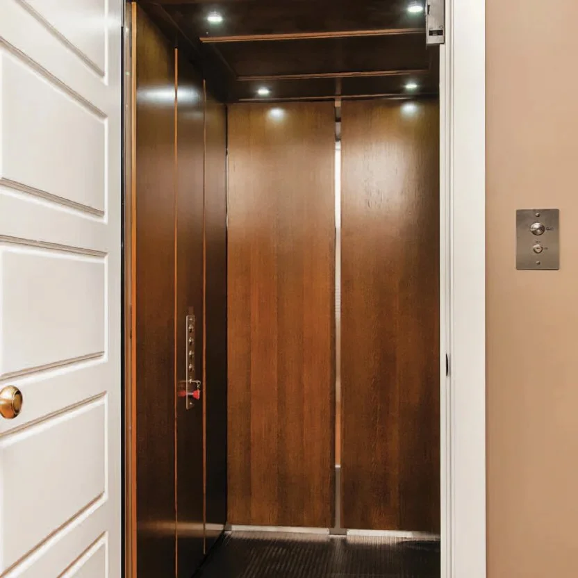 An interior images of a Butler Mobility - RAM Stratus elevator featuring a white door and wood interior paneling