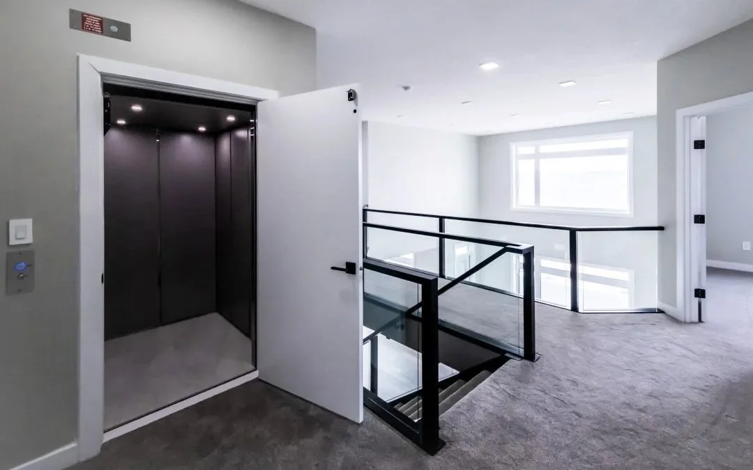 A Butler Mobility - RAM Crystal Elevator with a black interior opening to a grey hallway with grey carpet