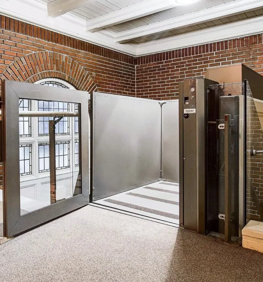Featuring a Butler Mobility - RAM Flex vertical platform lift in a commercial building with brick walls