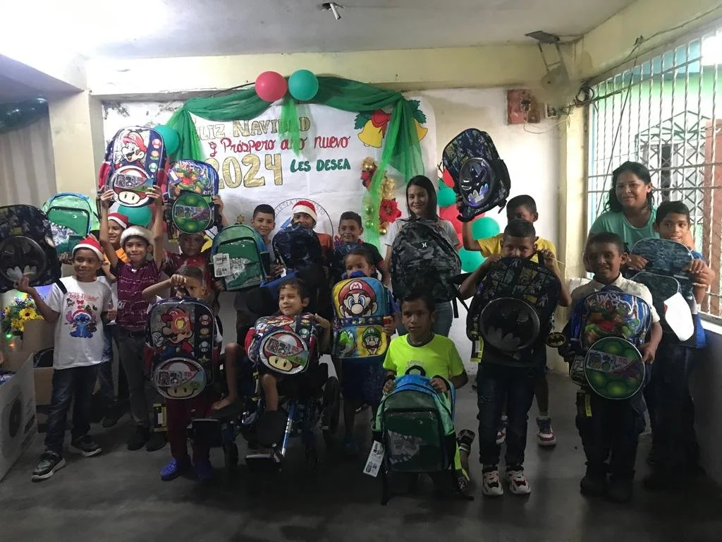 Boys receiving donated backpacks.