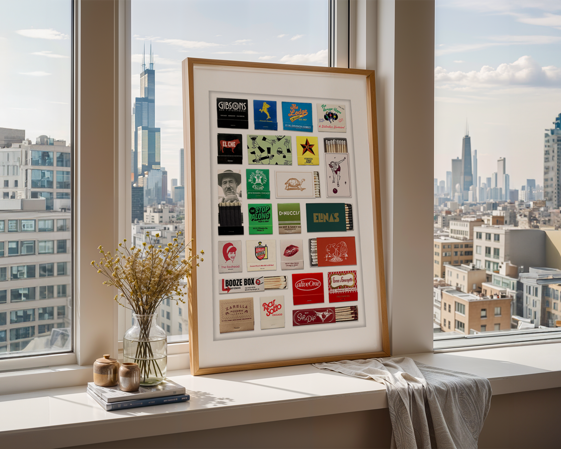 A white-framed display board featuring various stickers and small objects, positioned on a windowsill with a city skyline in the background. The cityscape includes skyscrapers, with the tallest building having two spires, and additional buildings can be seen beyond the window.