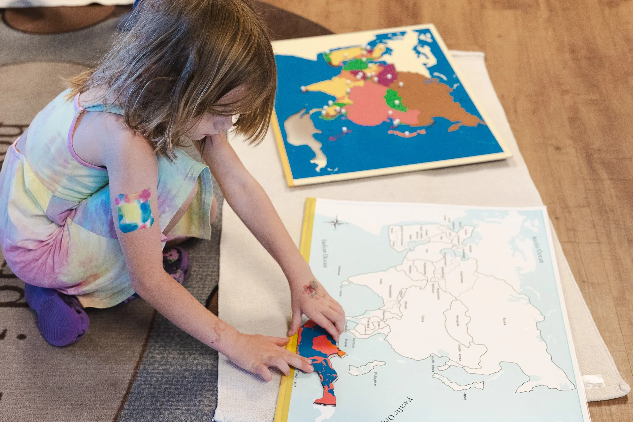 A young girl is playing with shapes on a map