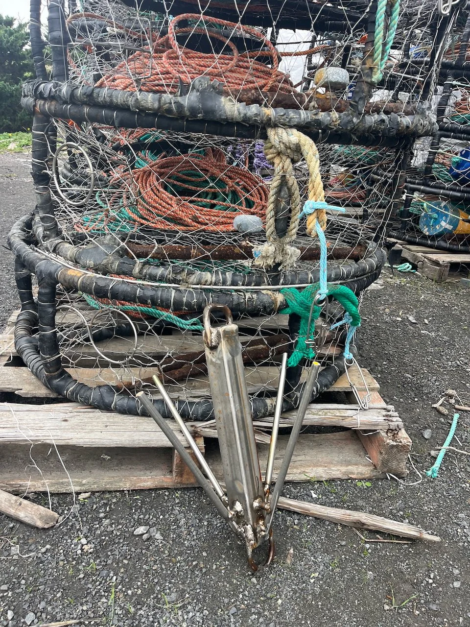 A grappling hook in front of a crab pot