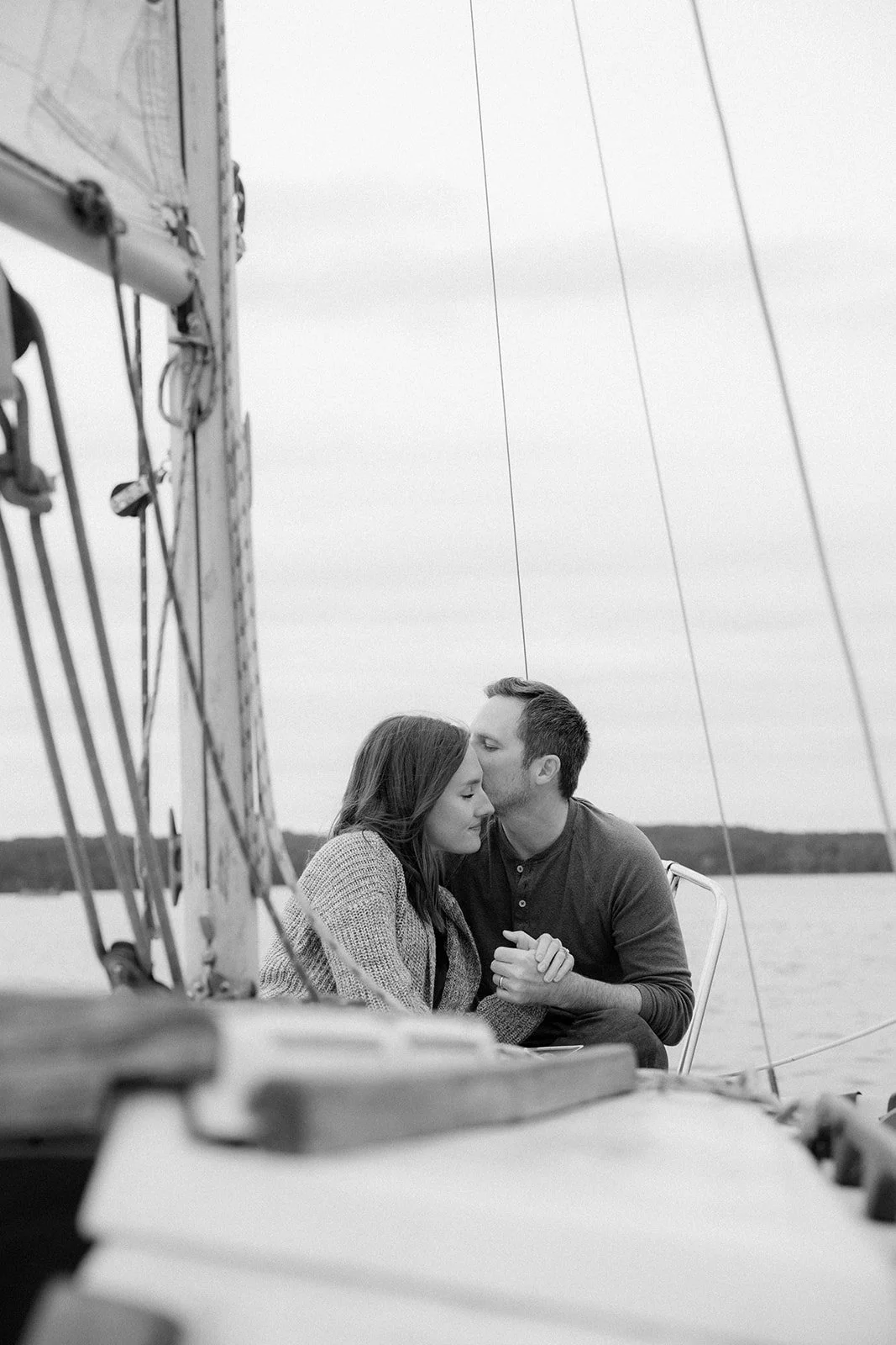 Couple sits on the deck of a sailboat sailing in Nashville, TN.