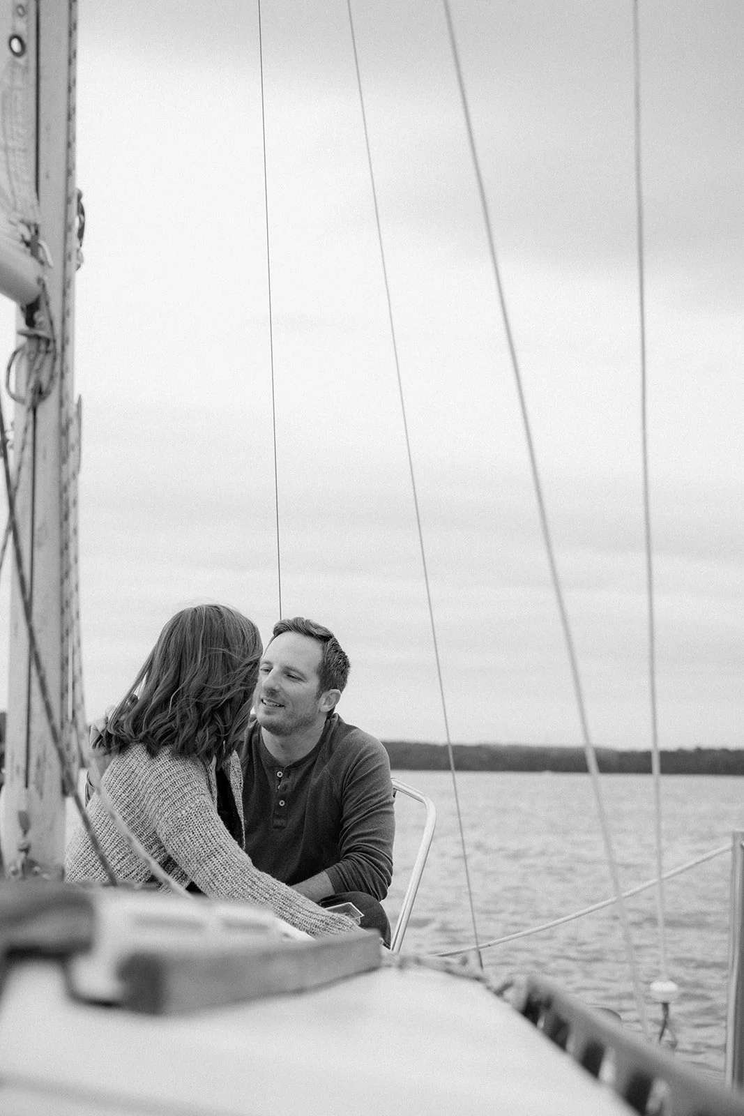 A husband looks lovingly at his wife as they sit on a sailboat in Nashville, TN.