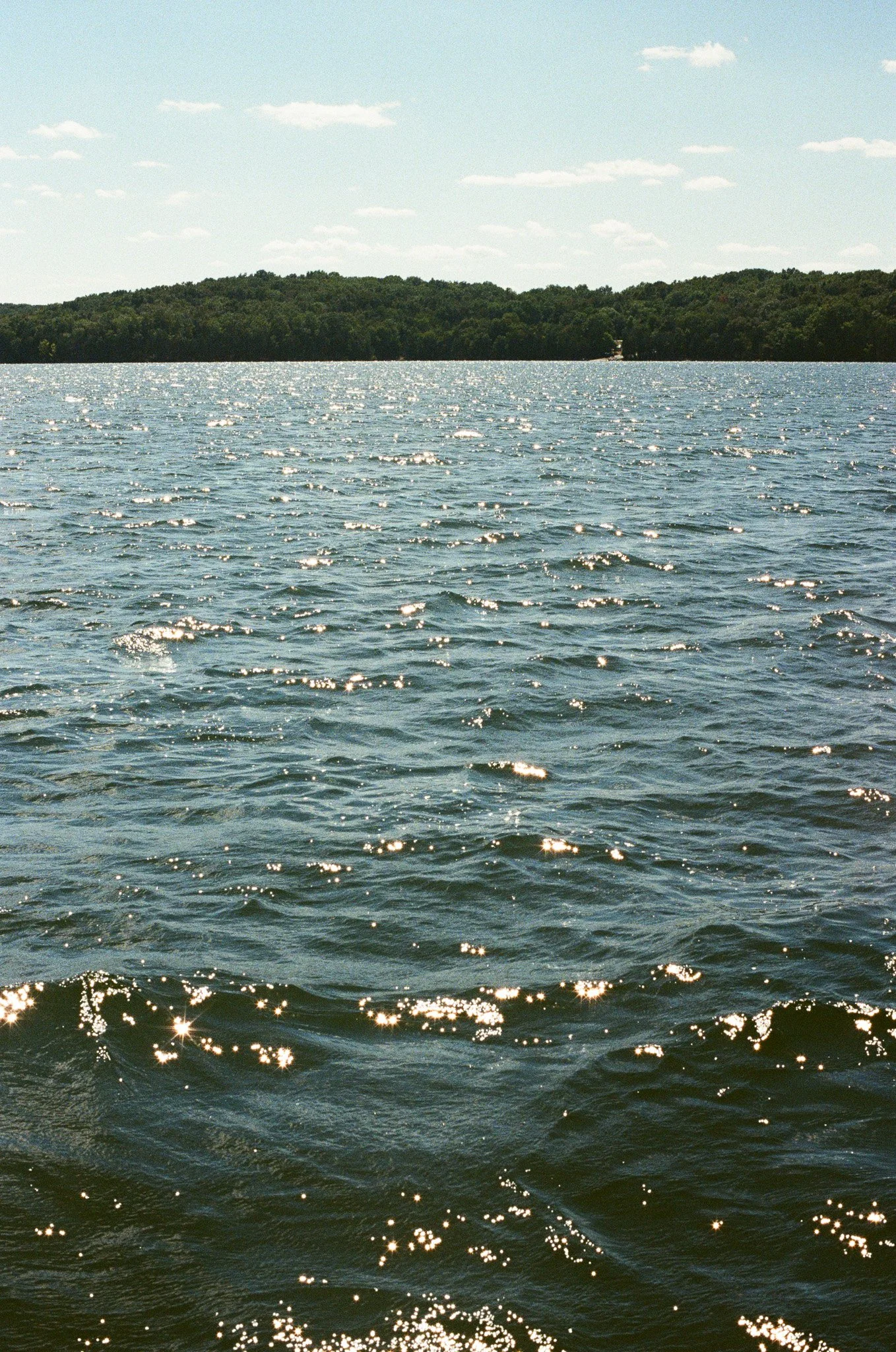 Photo capturing Percy Priest Lake glittering in the sun from the Whippoorwill Sailboat located in Nashville, TN.