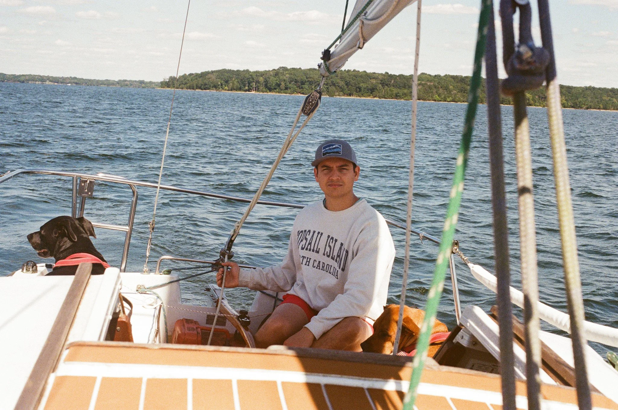 Captain of Whippoorwill Sailing Co steers sailboat ahead on Percy Priest Lake.