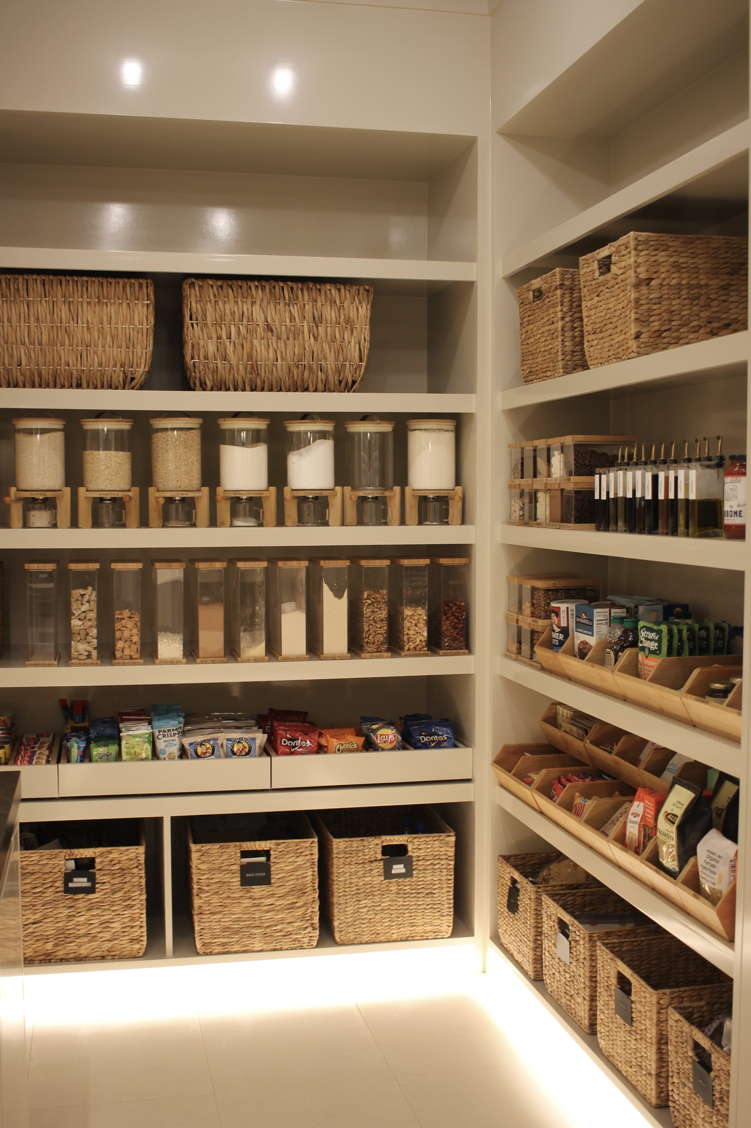 A large walk-in pantry that is organized with matching storage products