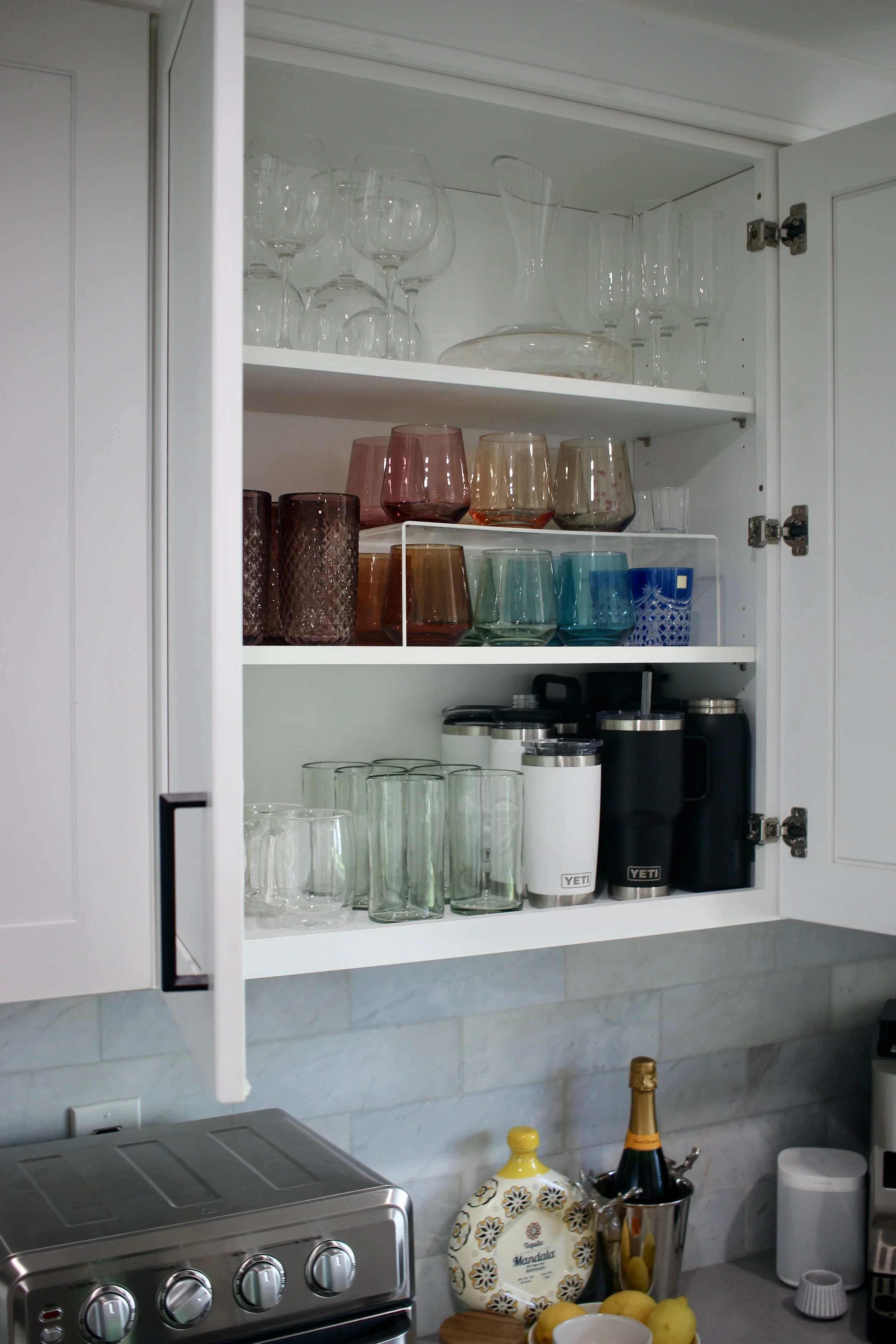 organized glasses and dishes in kitchen cabinet