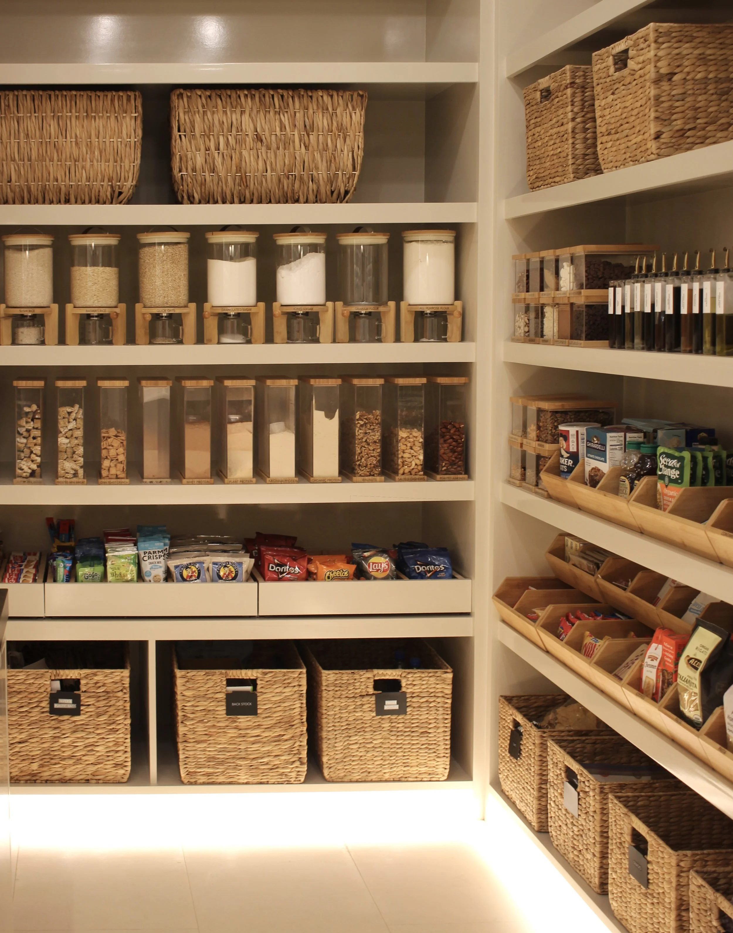 A large walk-in pantry that is organized with matching storage products