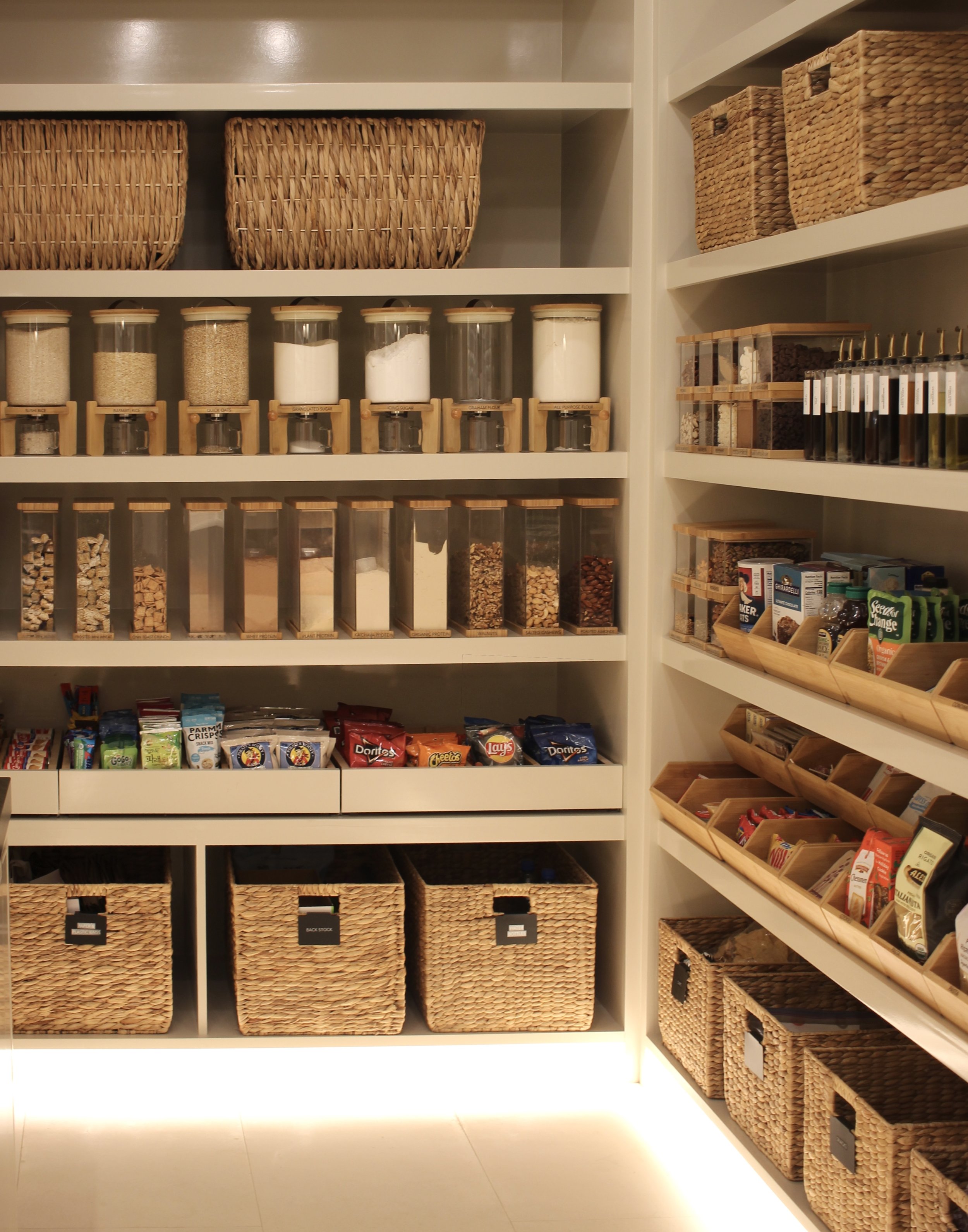 A large walk-in pantry that is organized with matching storage products