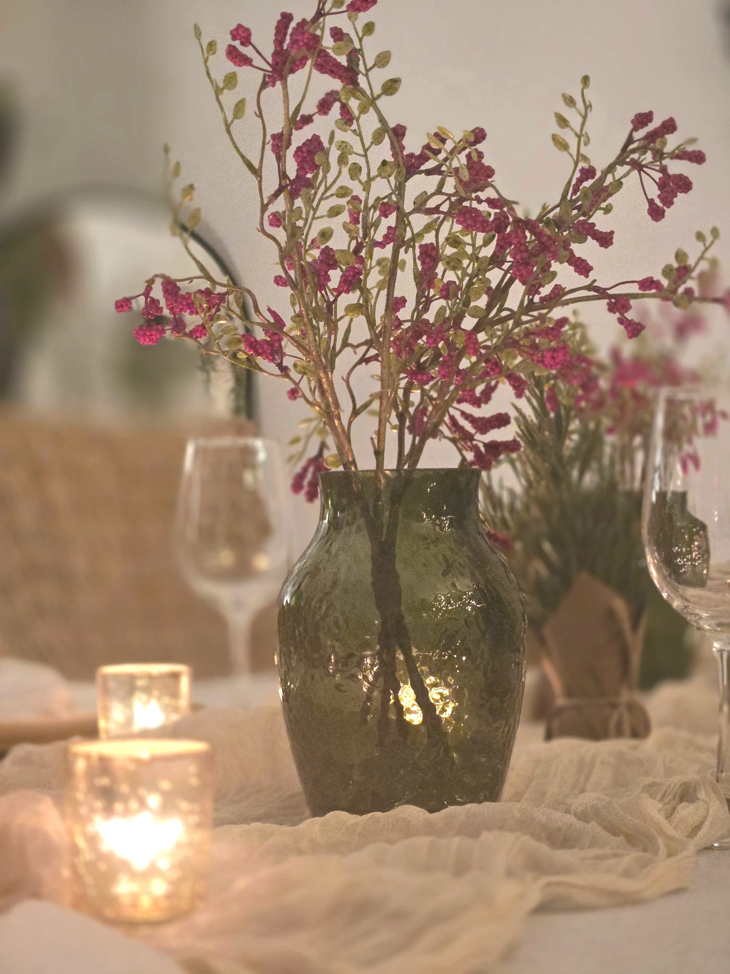 Green vase with red flowers on table scape gold candles at Oasis Collective Venue in Sarasota, FL