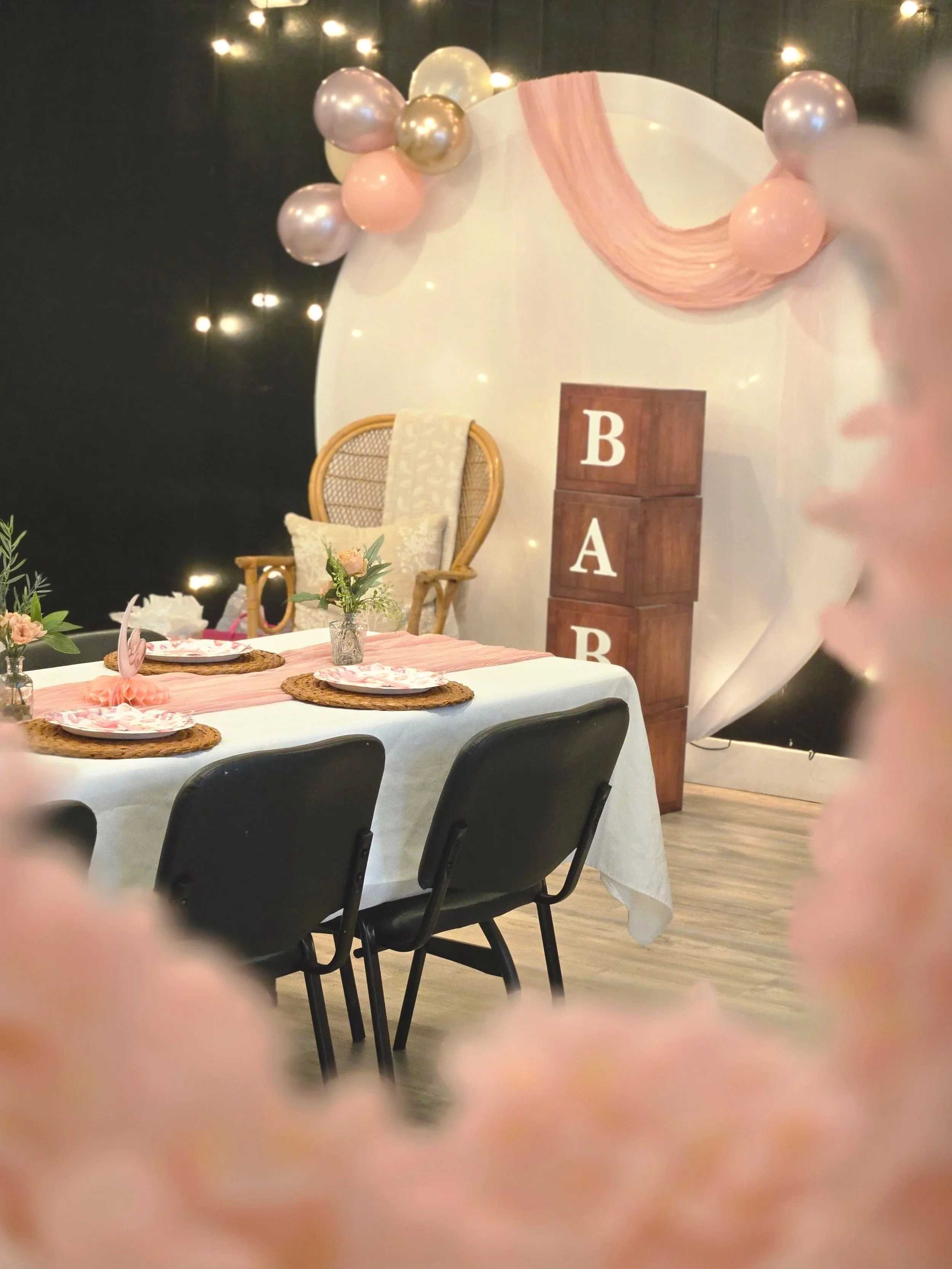 Wooden baby blocks, round balloon arch with pink table setting at a baby shower.  Oasis Events Collective is an event venue in Sarasota Florida.