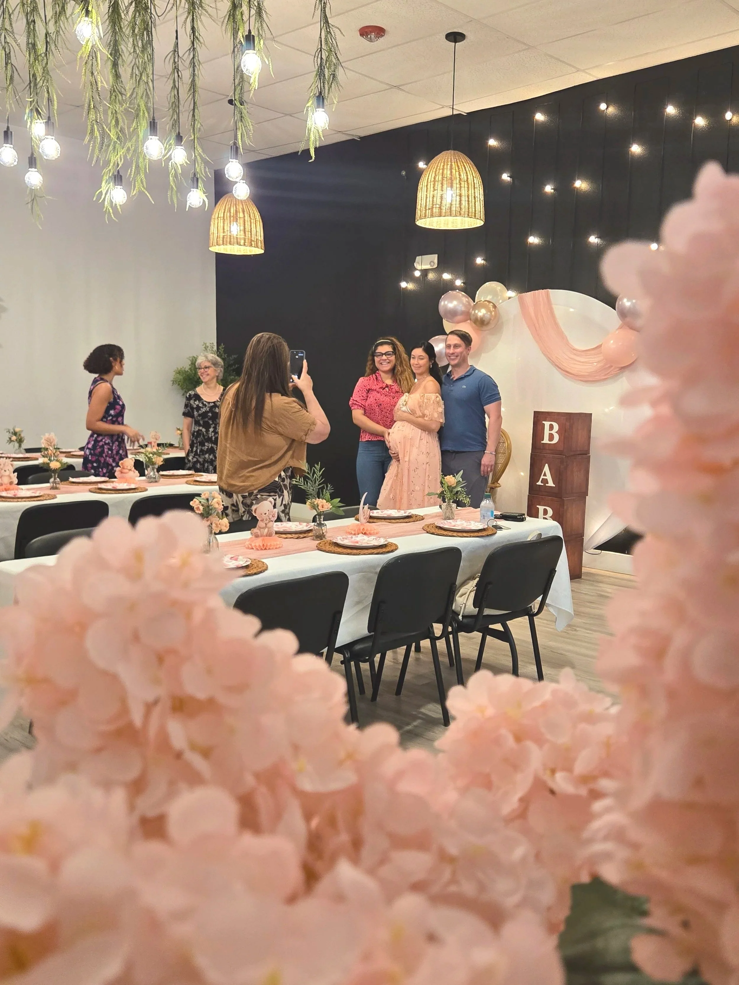 Mom and dad to be with pink flowers and table setting at Oasis Events Collective baby shower.  Small, cozy venue in Sarasota FL.
