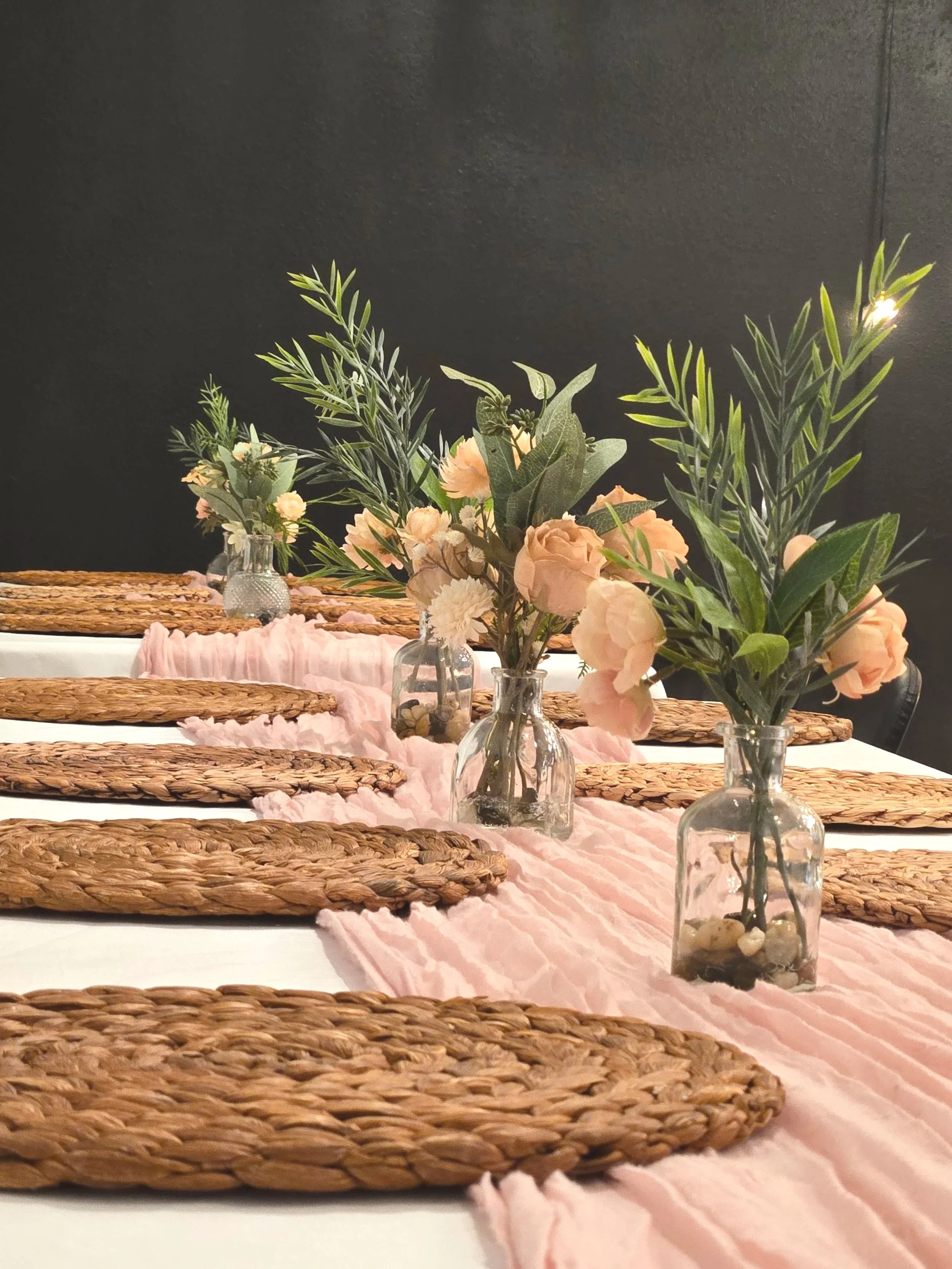 Pink budvases offered at Oasis Collective for your centerpieces.  Wicker placemats, pink table runners and white table cloths at a baby shower in an event venue in Sarasota Florida.