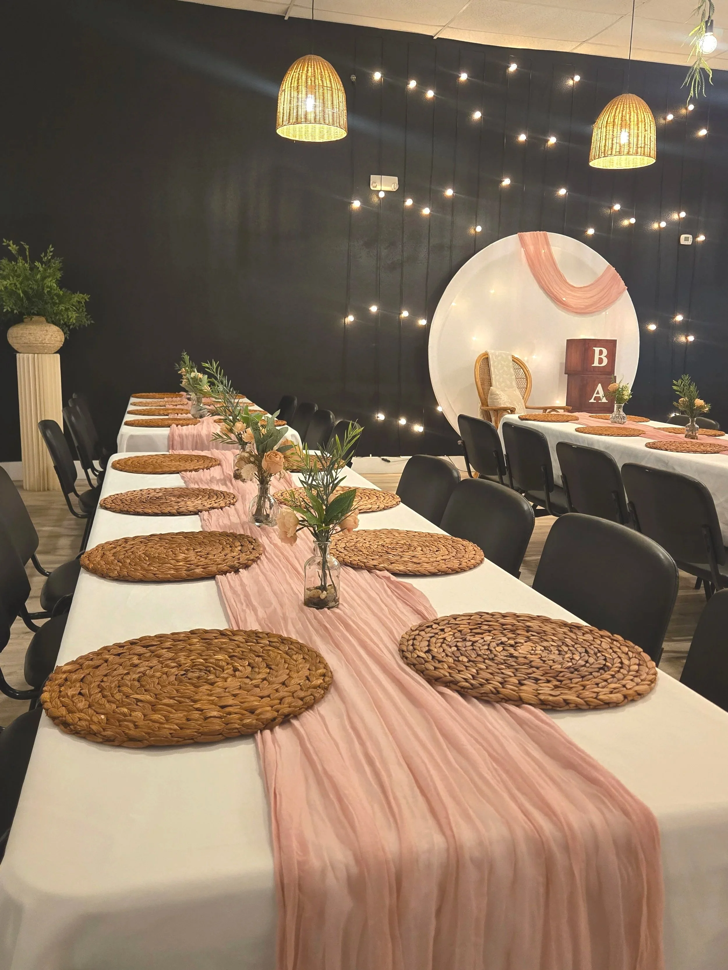 A baby shower setup at Oasis Events Collective in Sarasota Florida.  Pink table runners, round balloon arch and baby blocks in background.  Oasis is a cozy, intimate venue in Sarasota, Florida.