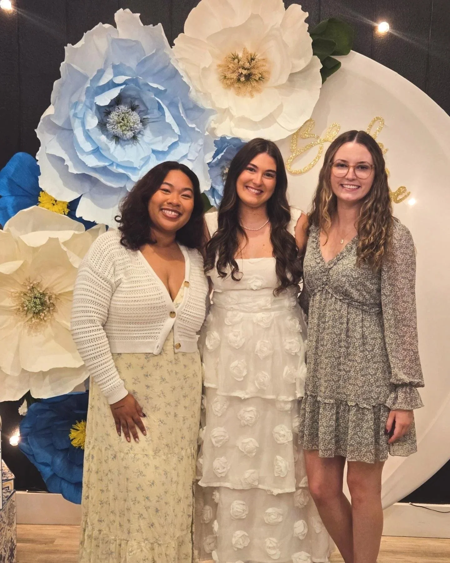 Bridal shower at Oasis Events Collective in Sarasota FL.  Small, cozy event venue.  Bride in front of arch with blue flowers with friends.