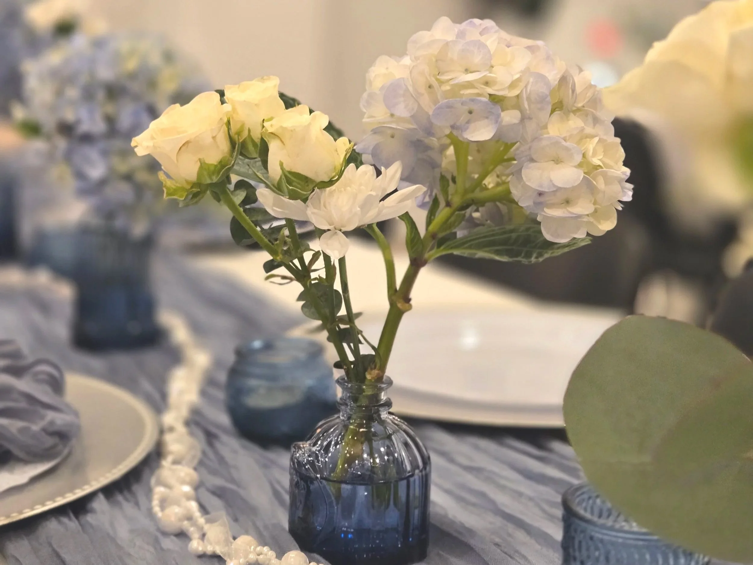 Blue vases in tablescape at Oasis Events Collective in Sarasota Florida. Intimate small venue for baby showers, micro weddings, bridal showers, gender reveals, birthday parties.