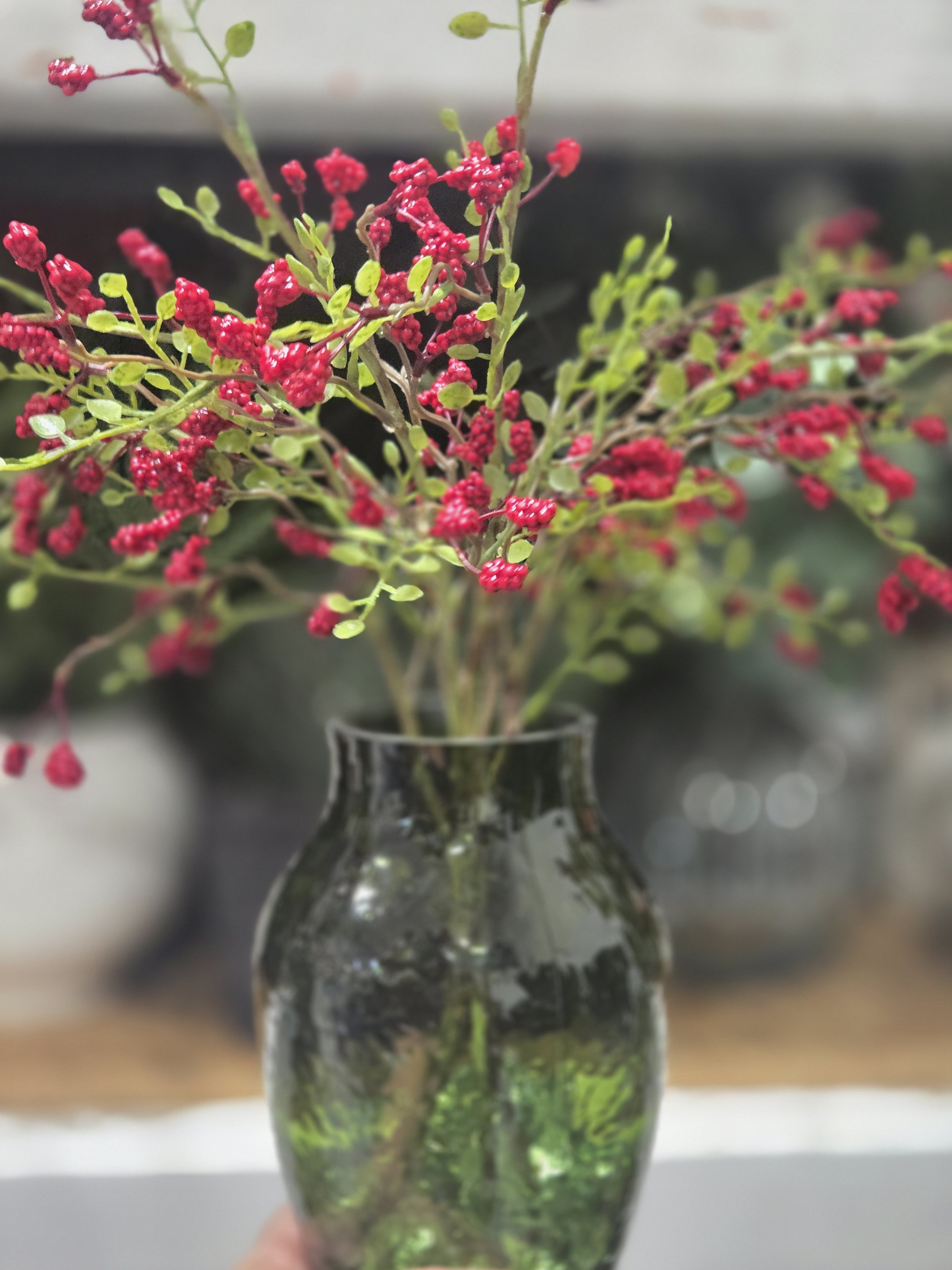 Red flower decor in green vase at Oasis Events Collective in Sarasota, FL.  Great decor for a Christmas event, baby shower, or bridal shower.