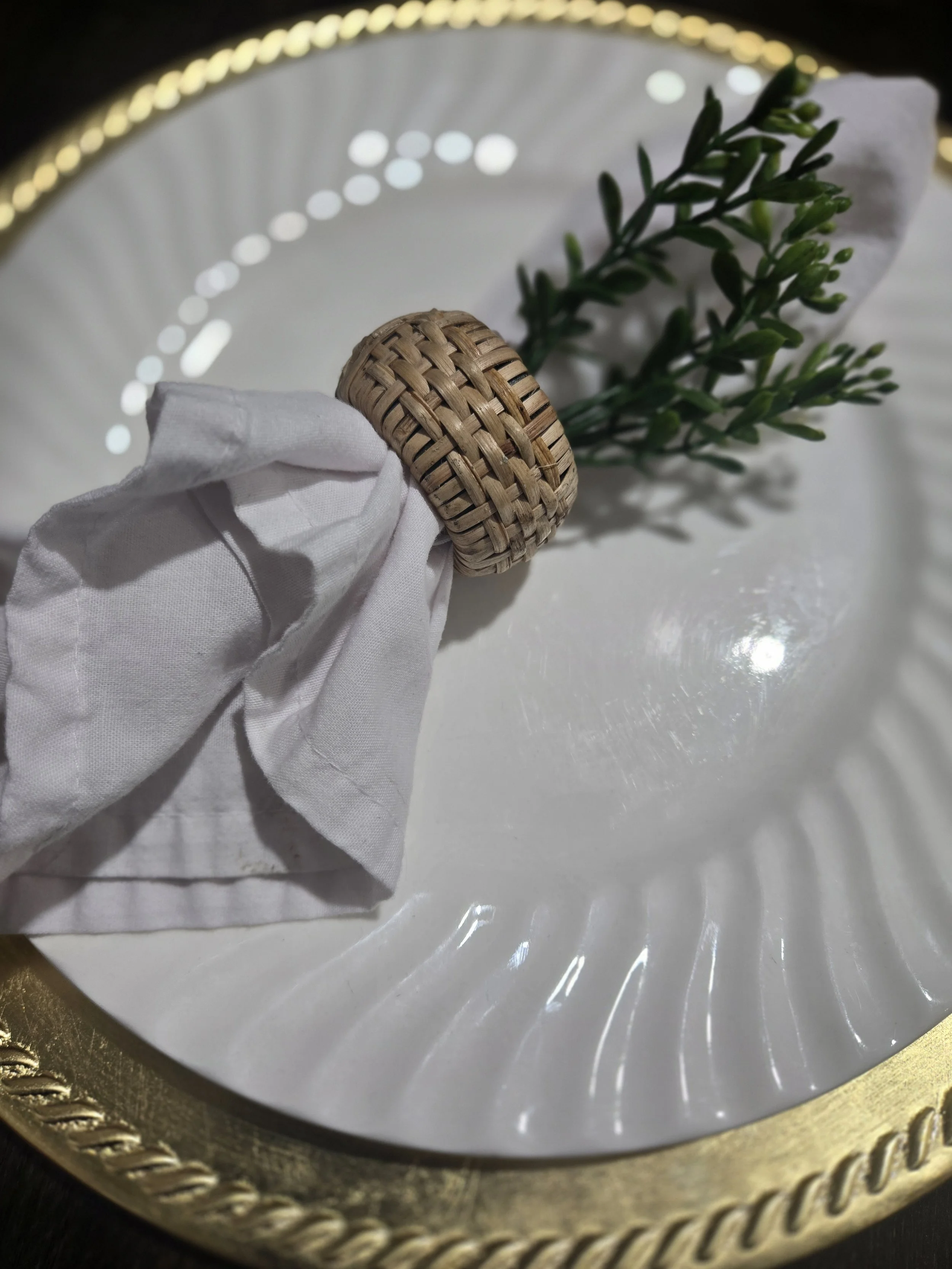 White plate on gold charger with white napkin and wicker napkin ring. At Oasis Events Collective in Sarasota, FL.  Great venue for baby showers, bridal showers, grad parties, Bible Study.