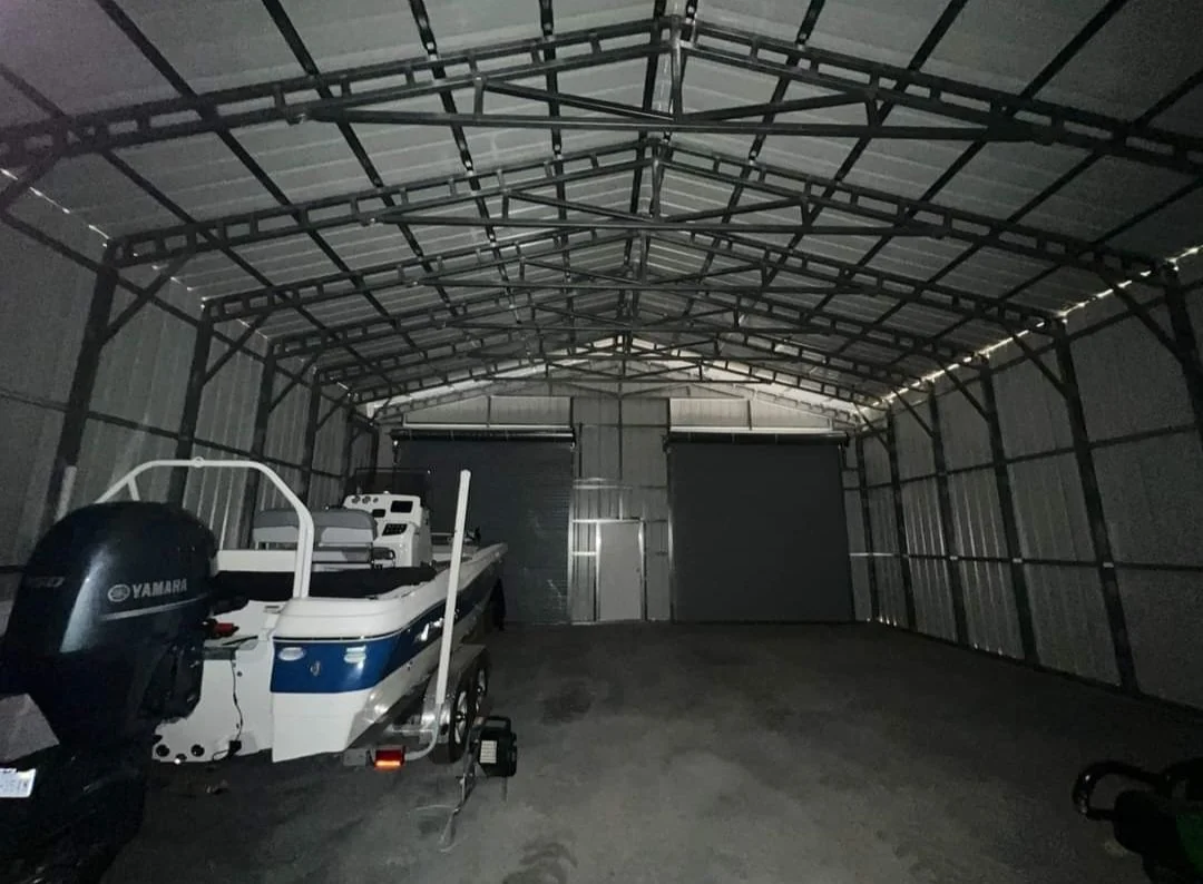 An empty metal storage unit with a boat and outboard motor inside.