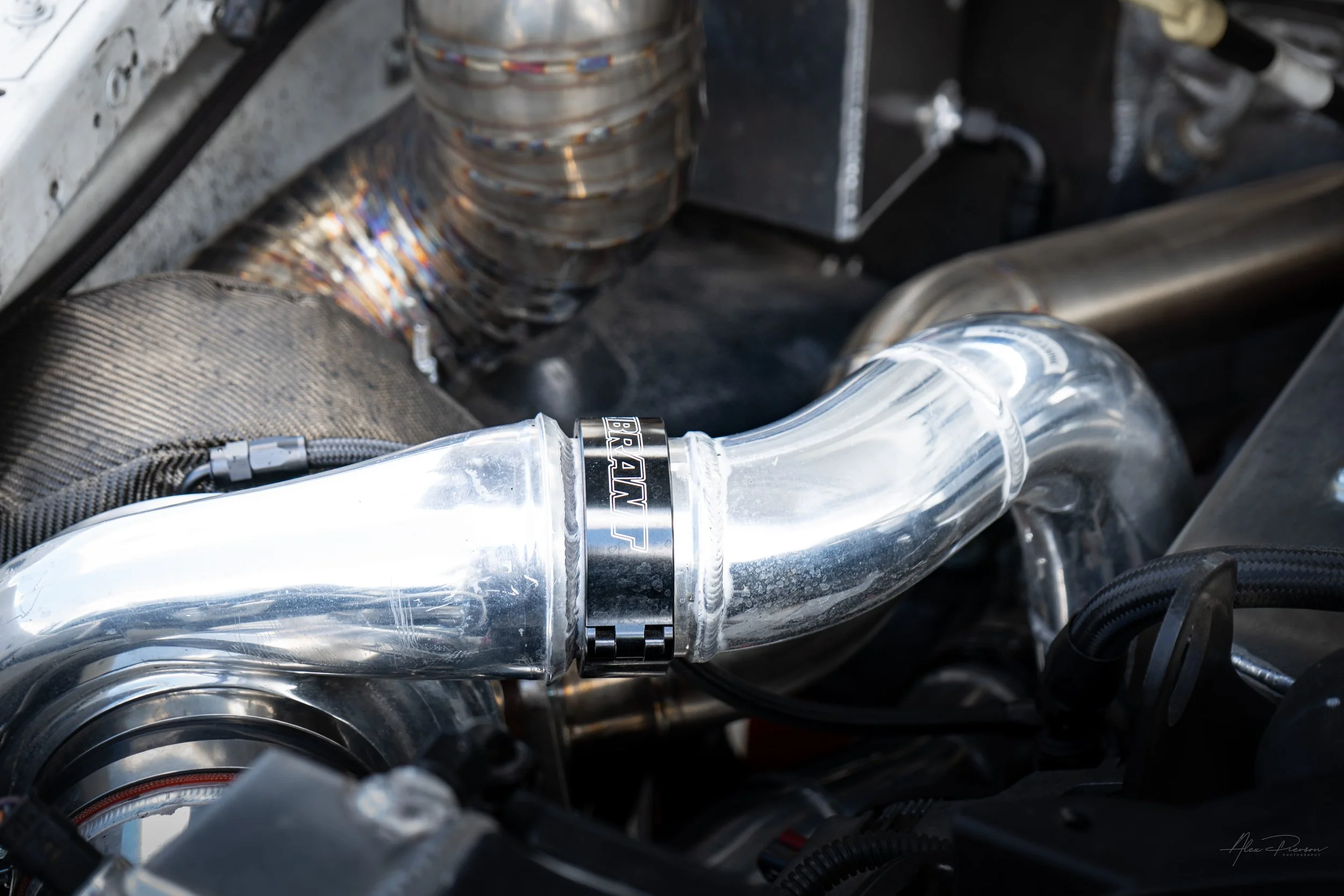 Detailed view of custom polished aluminum turbo piping secured with a heavy-duty black Vibrant Performance HD clamp in a Cummins diesel engine bay.
Vibrant Performance clamp, HD tube clamp, Cummins turbo piping, diesel engine bay.
heavy-duty Vibrant 