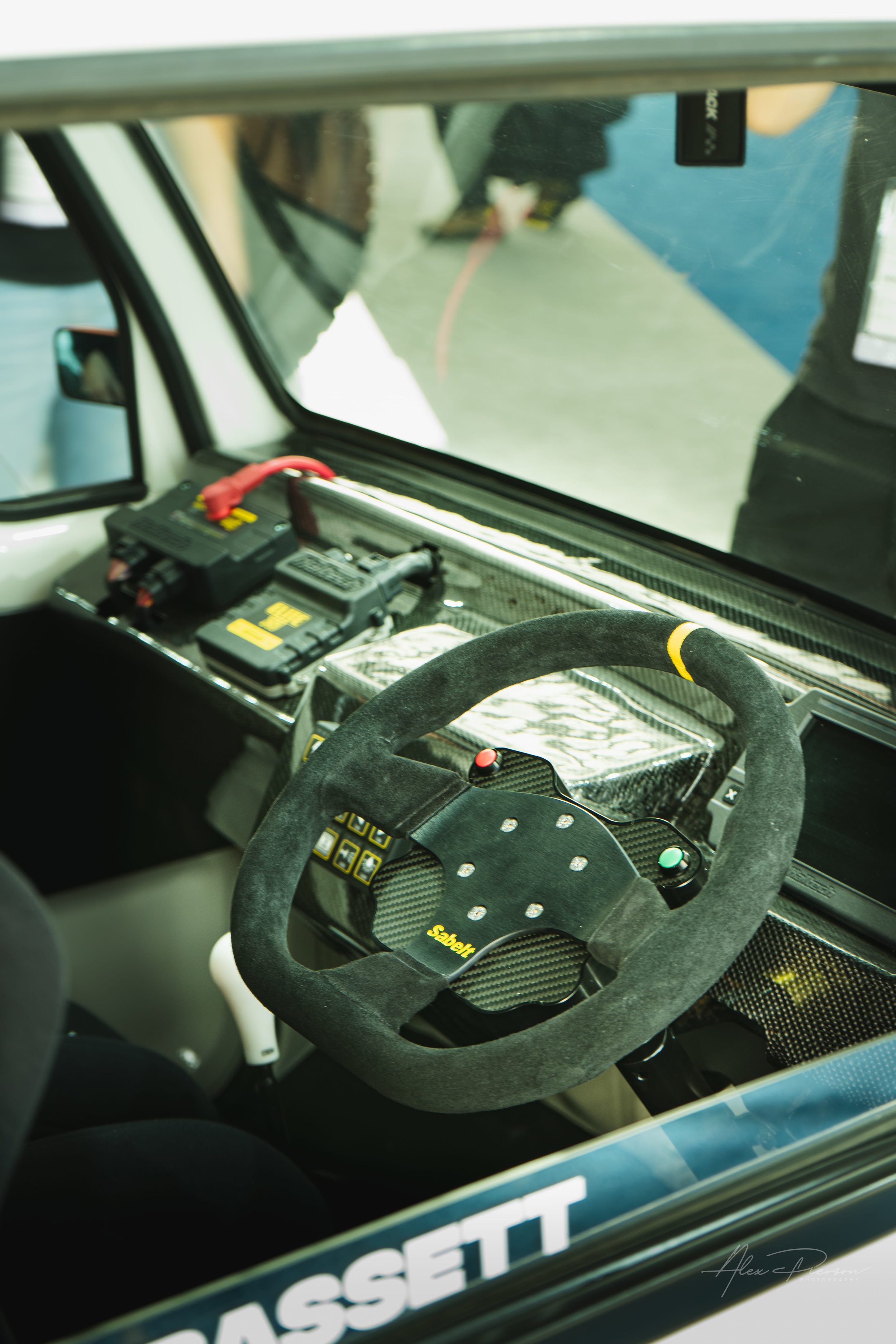 Interior of a modified track Kei truck showing a Sabelt suede steering wheel, carbon fiber dashboard, and aftermarket racing electronics at SEMA.

Take a look inside a custom time attack Kei truck from the SEMA Show. Featuring a custom carbon fiber d