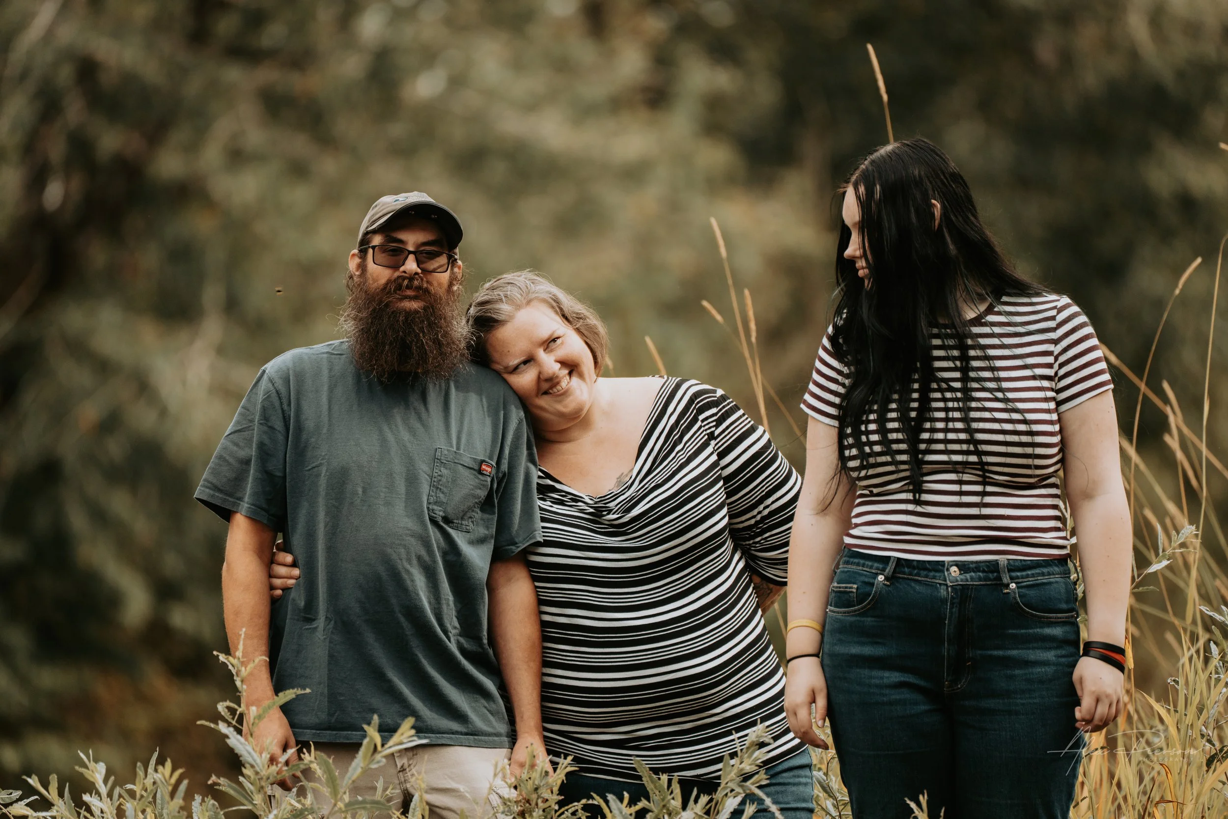 Mother and Daughter and Father posing for the camera during an autumn family photoshoot in their backyard in Montesano, WA- – Pacific Northwest lifestyle family and children's photography.