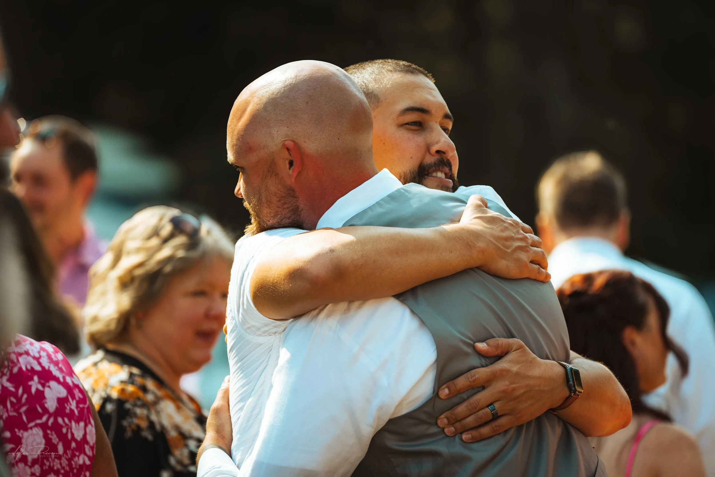 groom and guest hugging during his wedding in Olympia, wa