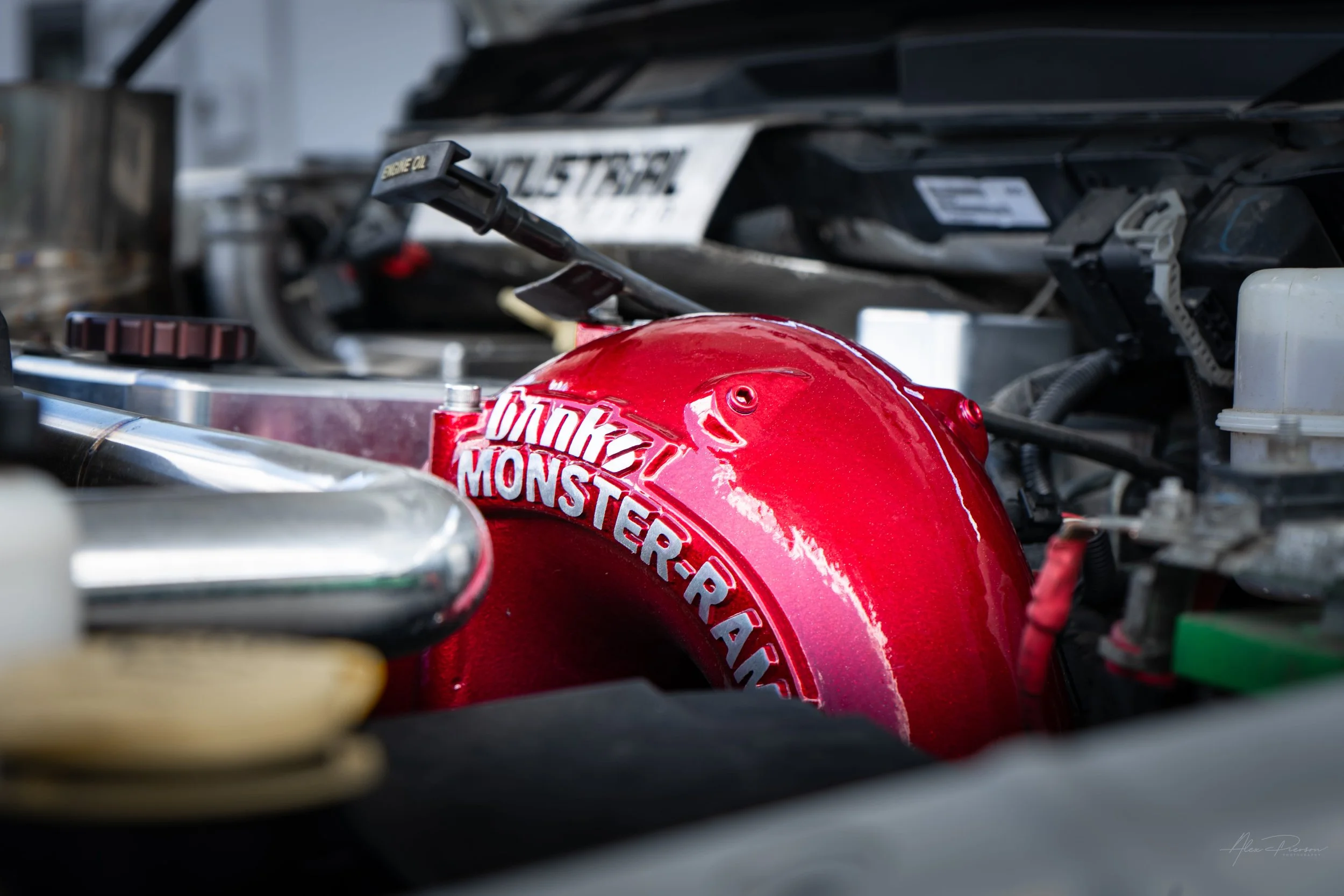Close-up of a bright candy red Banks Power Monster-Ram intake elbow installed on a highly modified 6.7L Cummins diesel engine.
Banks Monster Ram, Cummins intake, red diesel intake, 6.7 Cummins upgrades.
Banks Monster-Ram intake elbow upgrade for 6.7L