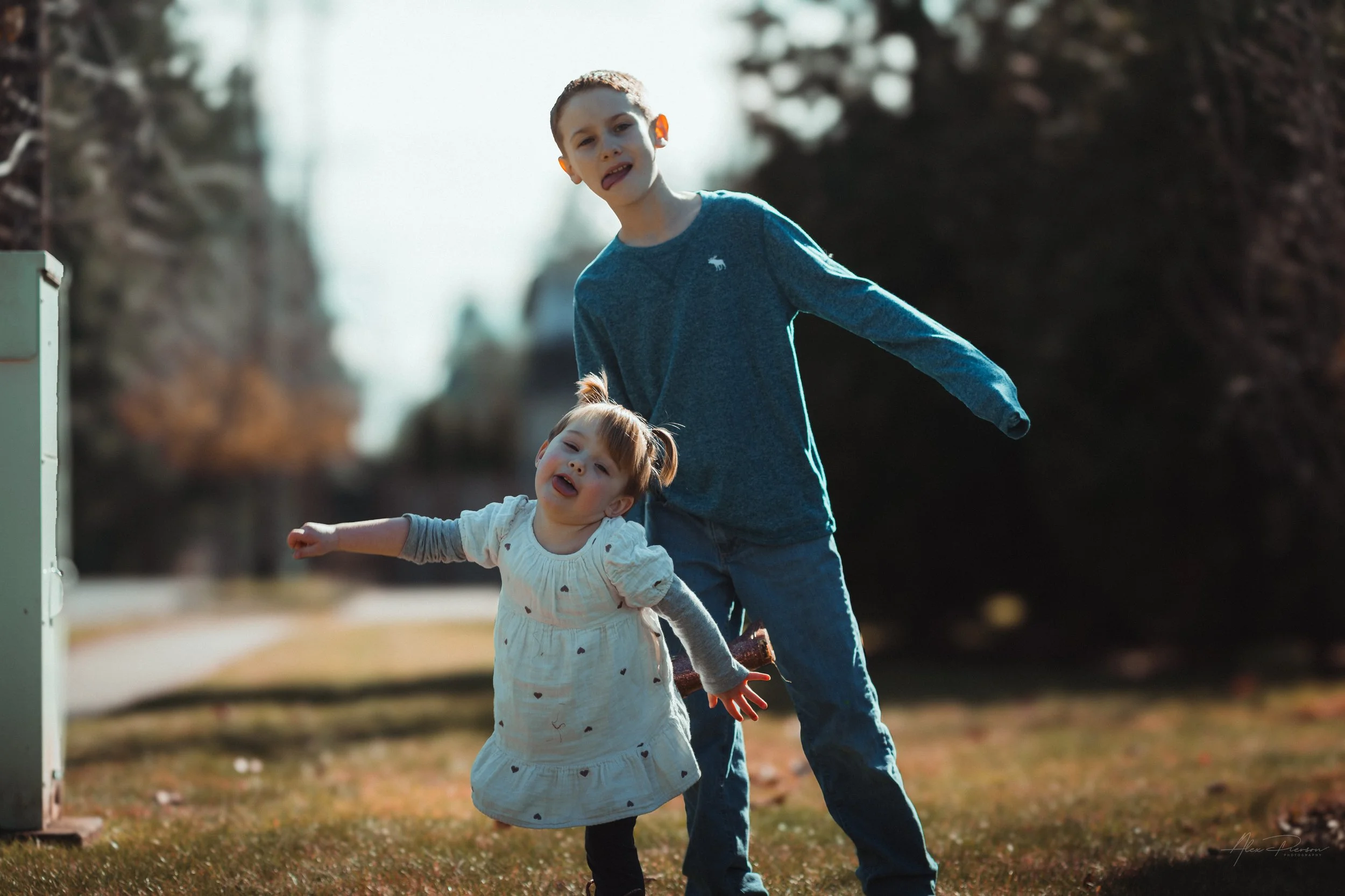 Little girl playfully making silly faces while balancing on one foot with her cousin during a candid family photo session Tumwater, WA – Pacific Northwest lifestyle family and children's photography.