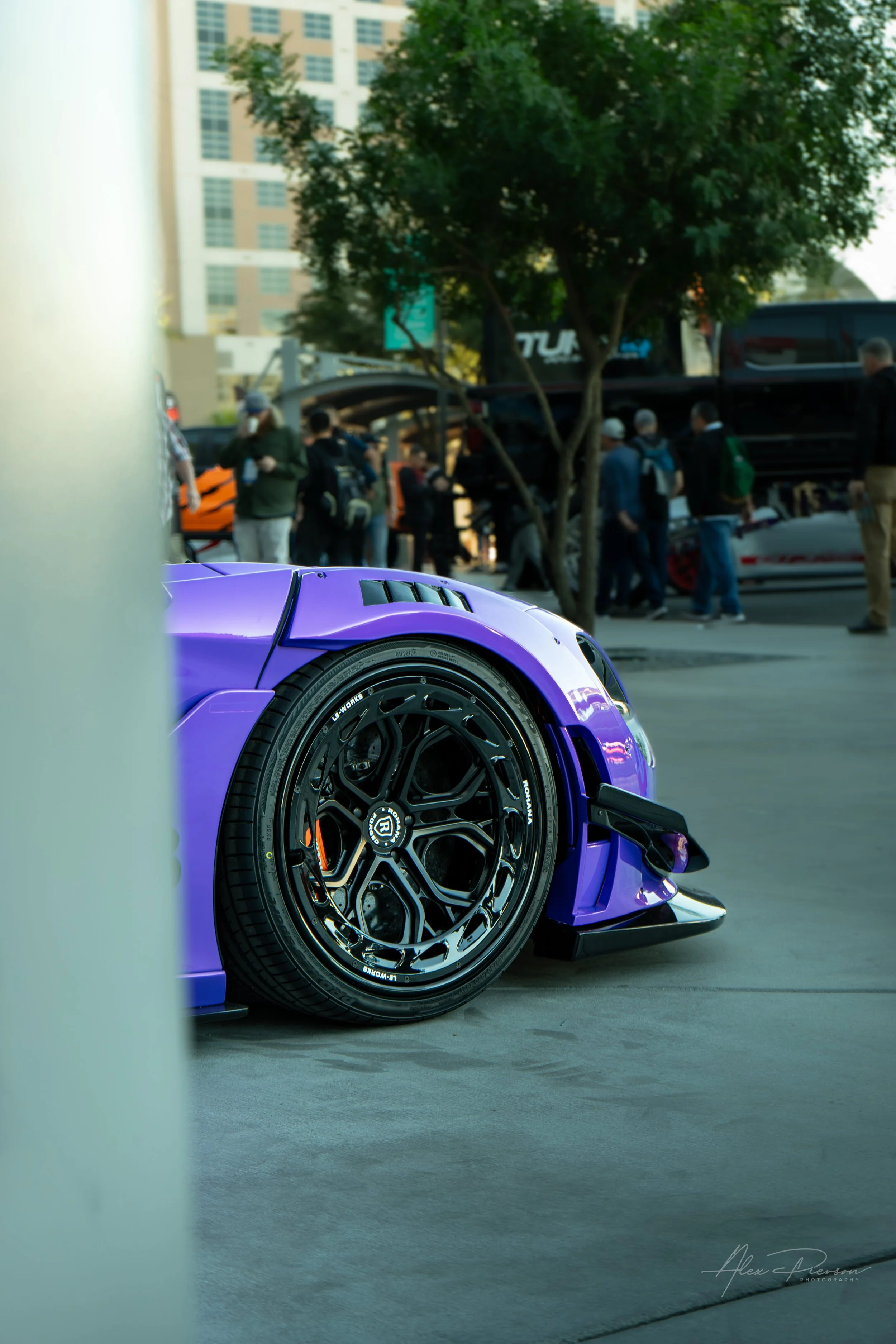 Close up of aftermarket black wheels and widebody fender fitment on a purple McLaren parked at SEMA Las Vegas.
Tucked perfectly. A detailed shot highlighting the custom black aftermarket wheels and aggressive widebody fender fitment of a purple McLar