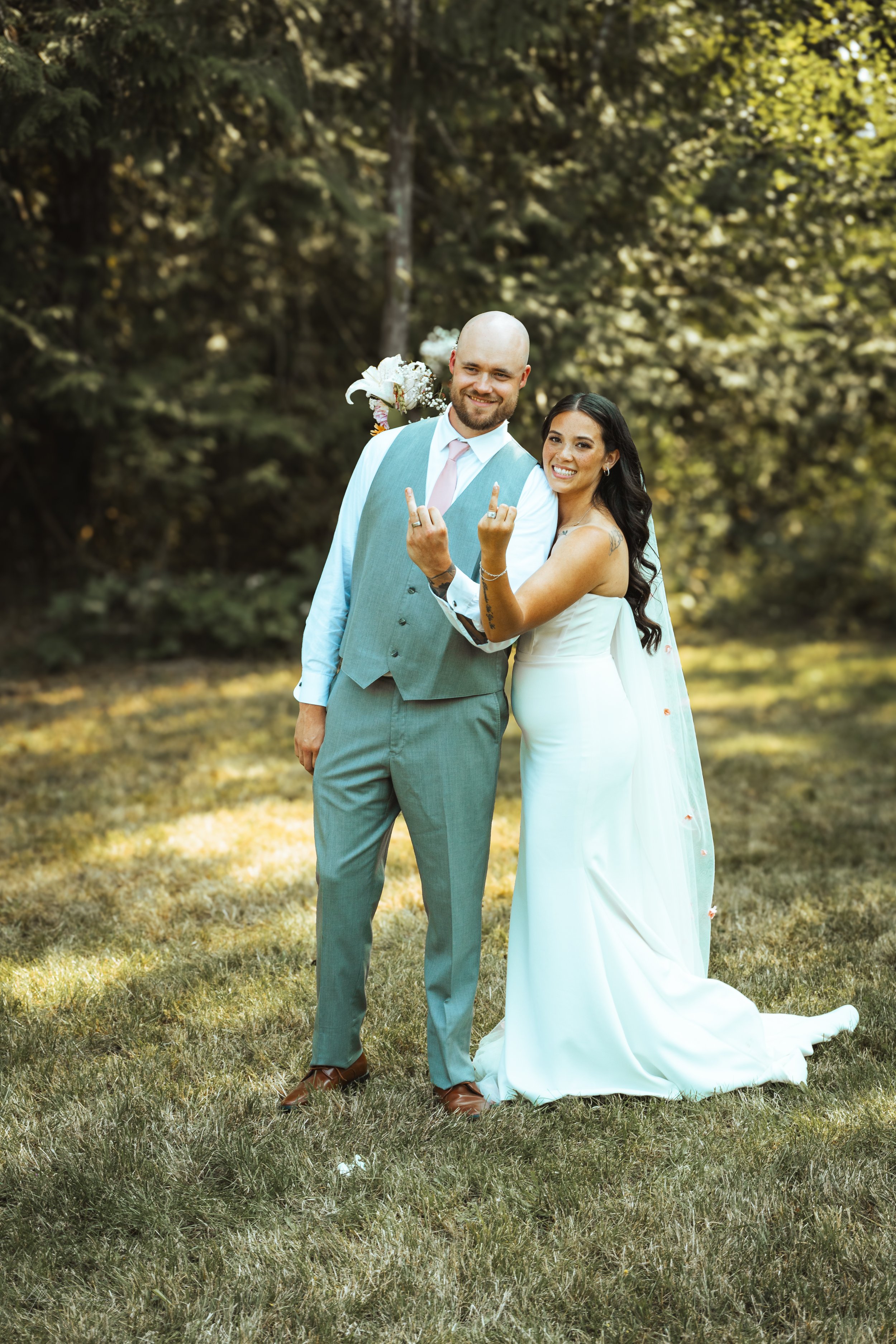 bride and groom showing the camera their wedding rings during their wedding in Olympia, wa