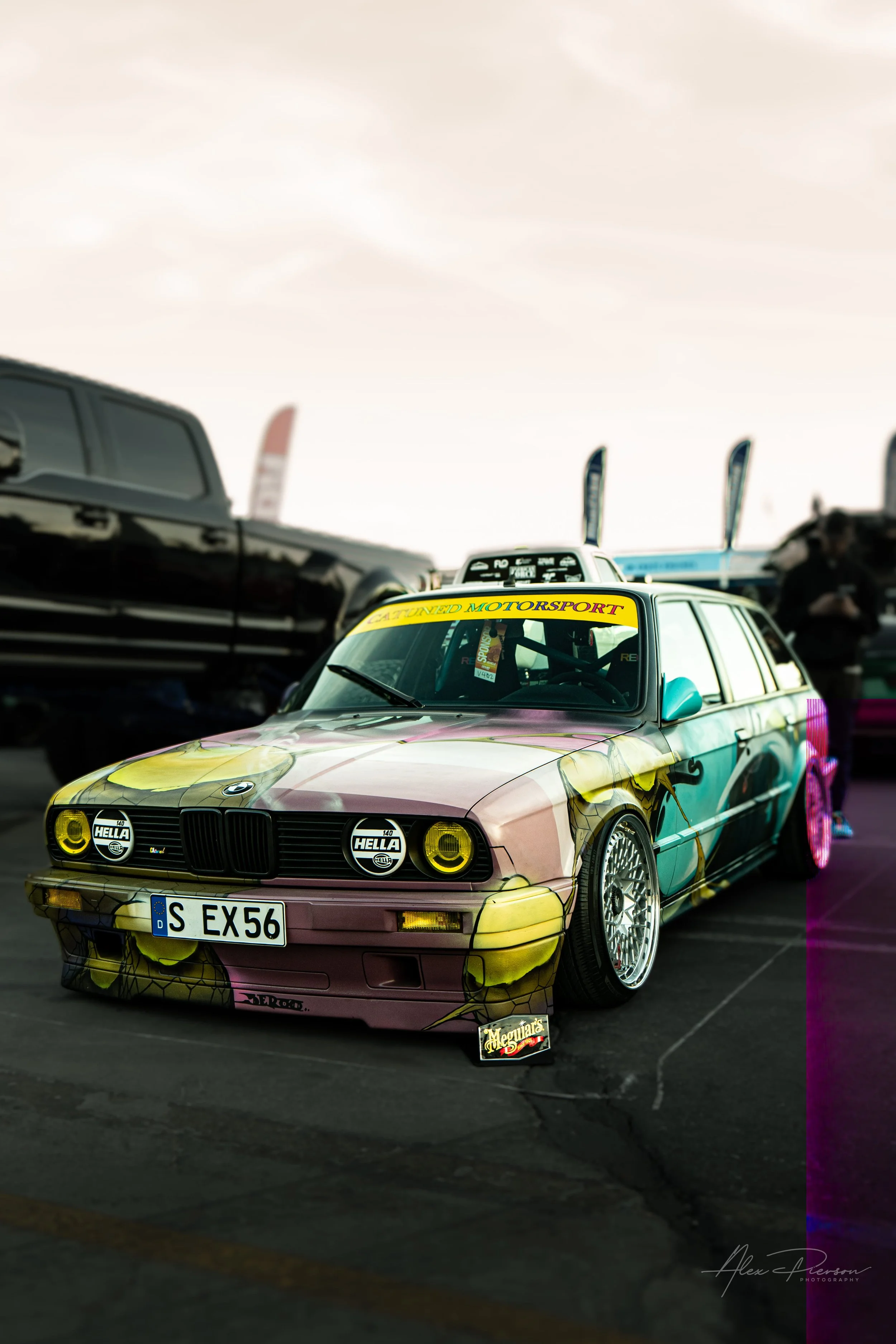 A lowered BMW E30 wagon featuring a vibrant graffiti art wrap and yellow tinted headlights at SEMA in Las Vegas.
Standing out from the crowd. This classic BMW E30 wagon (Touring) grabs attention with an incredibly detailed, vibrant graffiti art wrap 