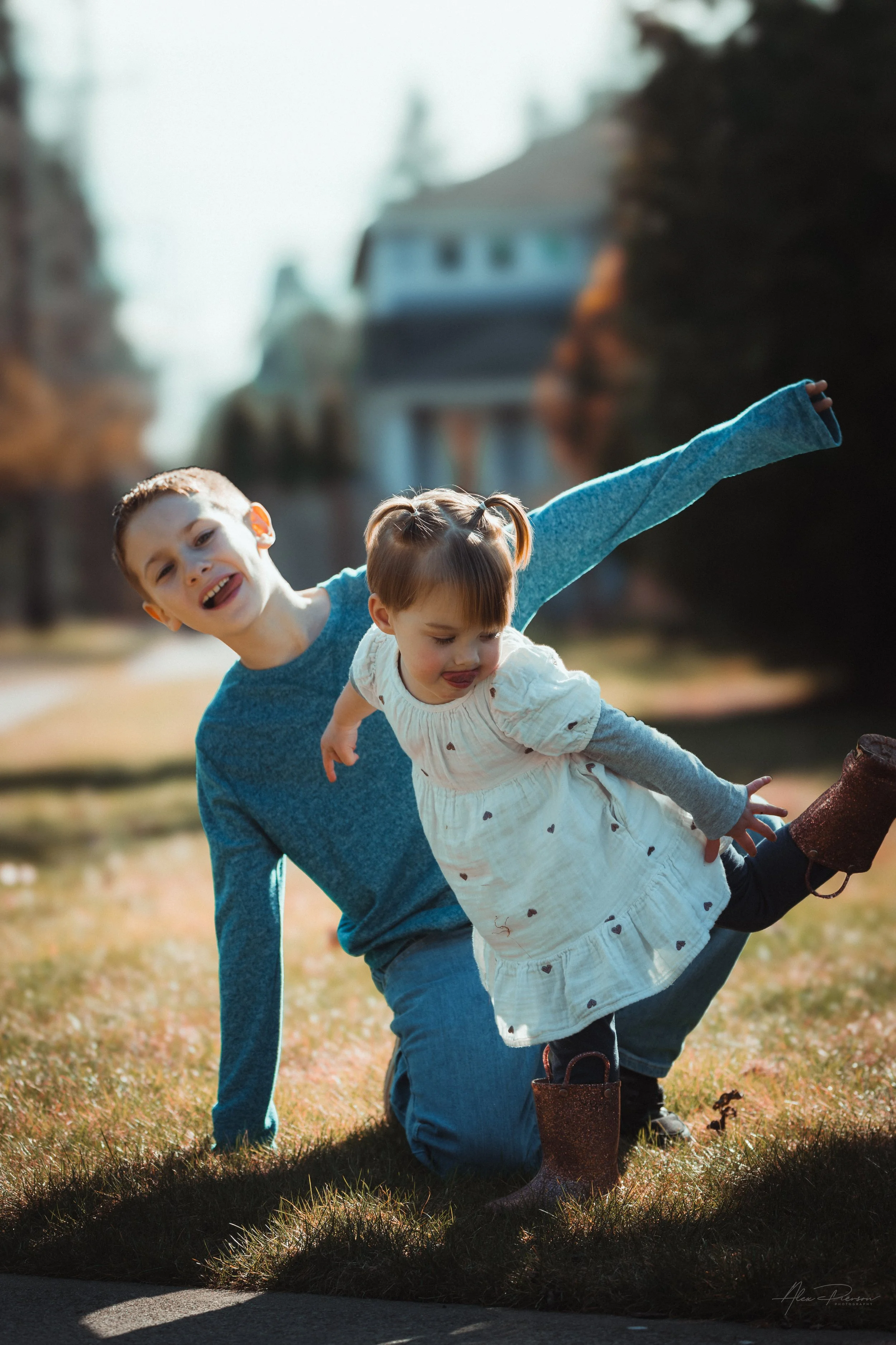Little girl playfully making silly faces while glancing on one foot with her cousin during a candid family photo session Tumwater, WA – Pacific Northwest lifestyle family and children's photography.