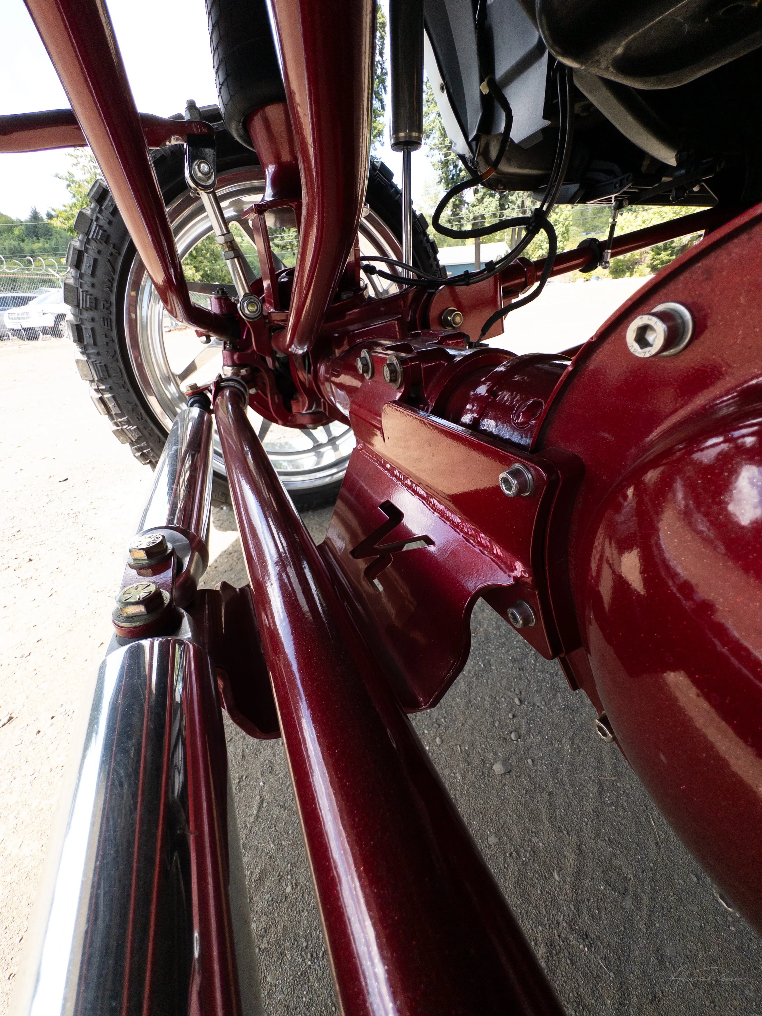 Close-up underneath a custom Ram 2500 showing a beautifully detailed red powder-coated rear axle, custom fabricated Kelderman air suspension brackets, and heavy-duty links.

 Kelderman suspension brackets, red rear axle, truck suspension links, Ram 2