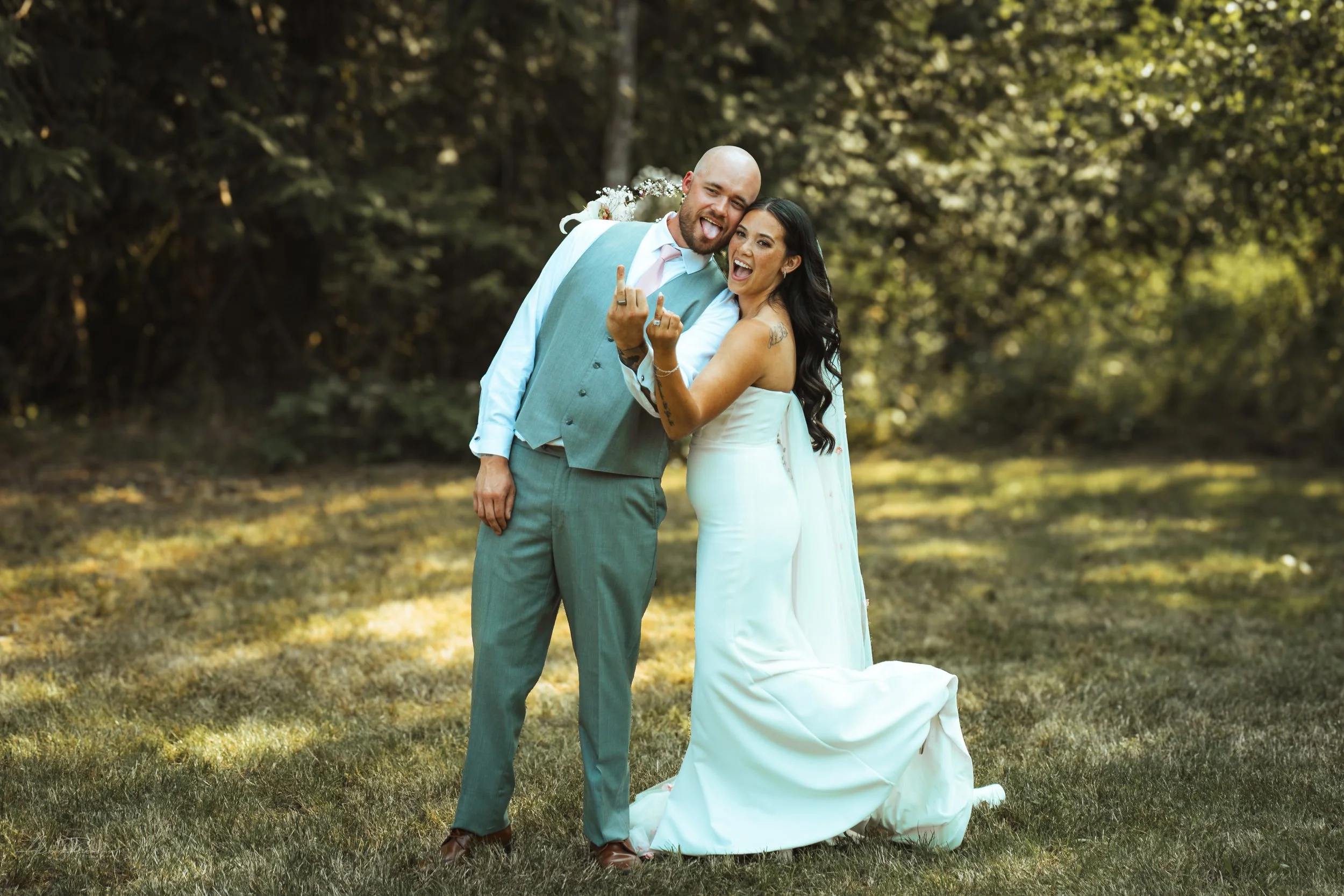 bride and groom showing the camera their wedding rings during their wedding in Olympia, wa