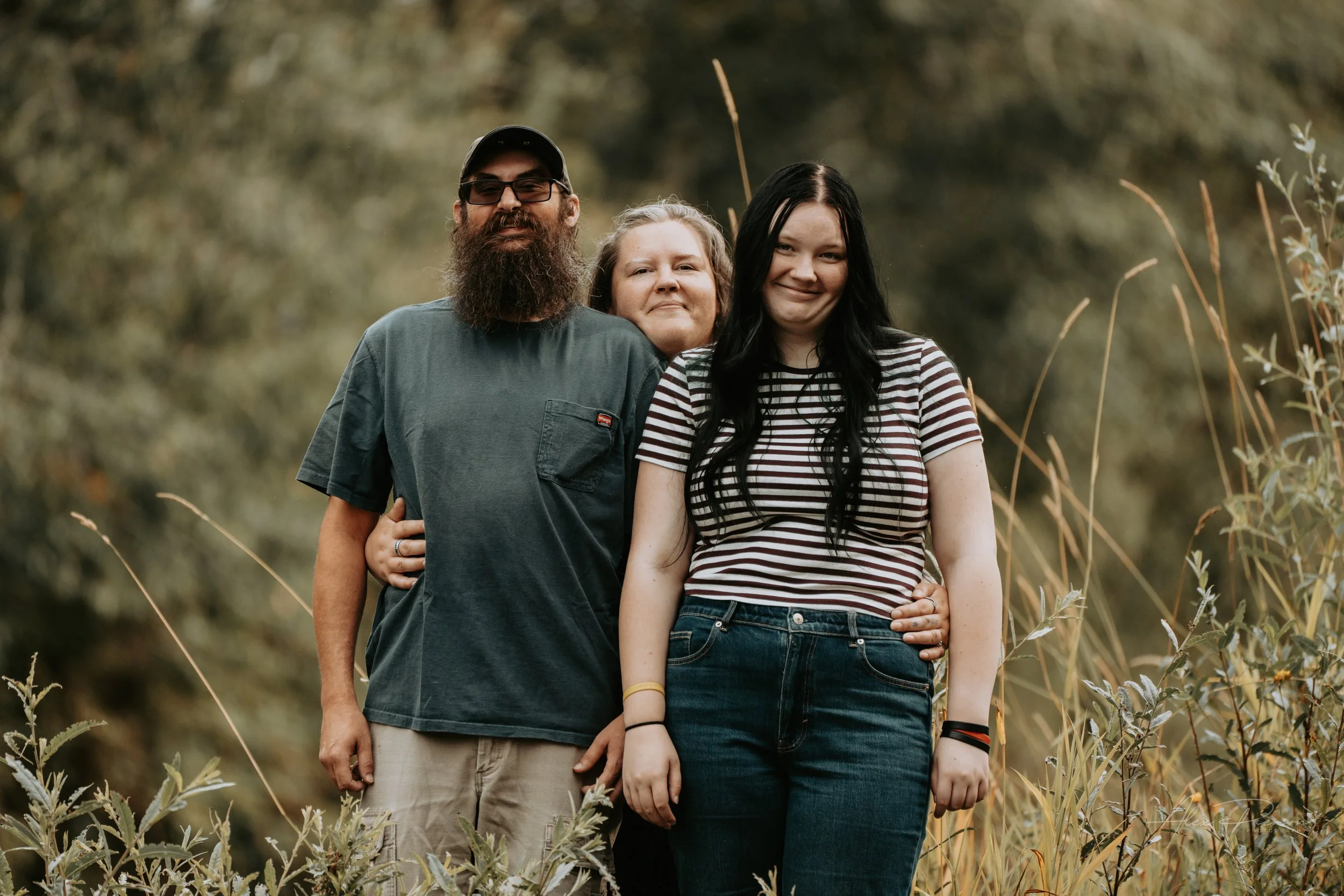 Mother and Daughter and Father posing for the camera during an autumn family photoshoot in their backyard in Montesano, WA- – Pacific Northwest lifestyle family and children's photography.