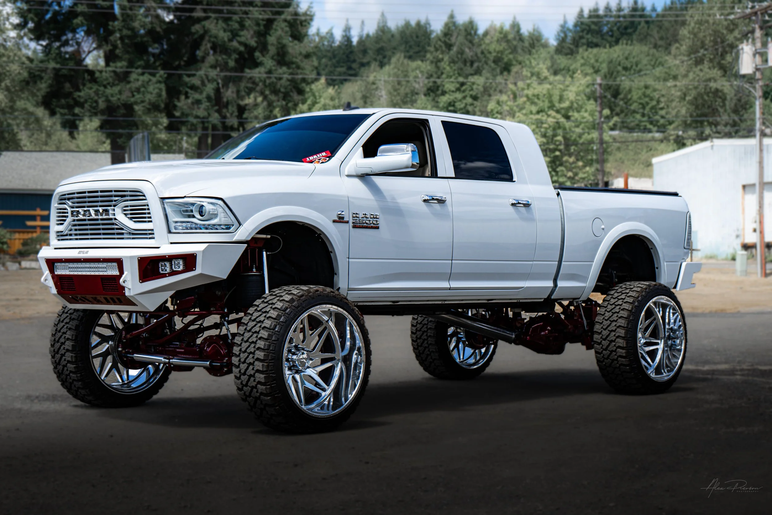 Side profile of a customized Dodge Ram 2500 featuring an aggressive red Kelderman air suspension lift kit, Bodyguard front bumper, and massive polished forged wheels.
 Ram 2500 side profile, Kelderman air lift kit, Bodyguard bumper truck, lifted Dodg