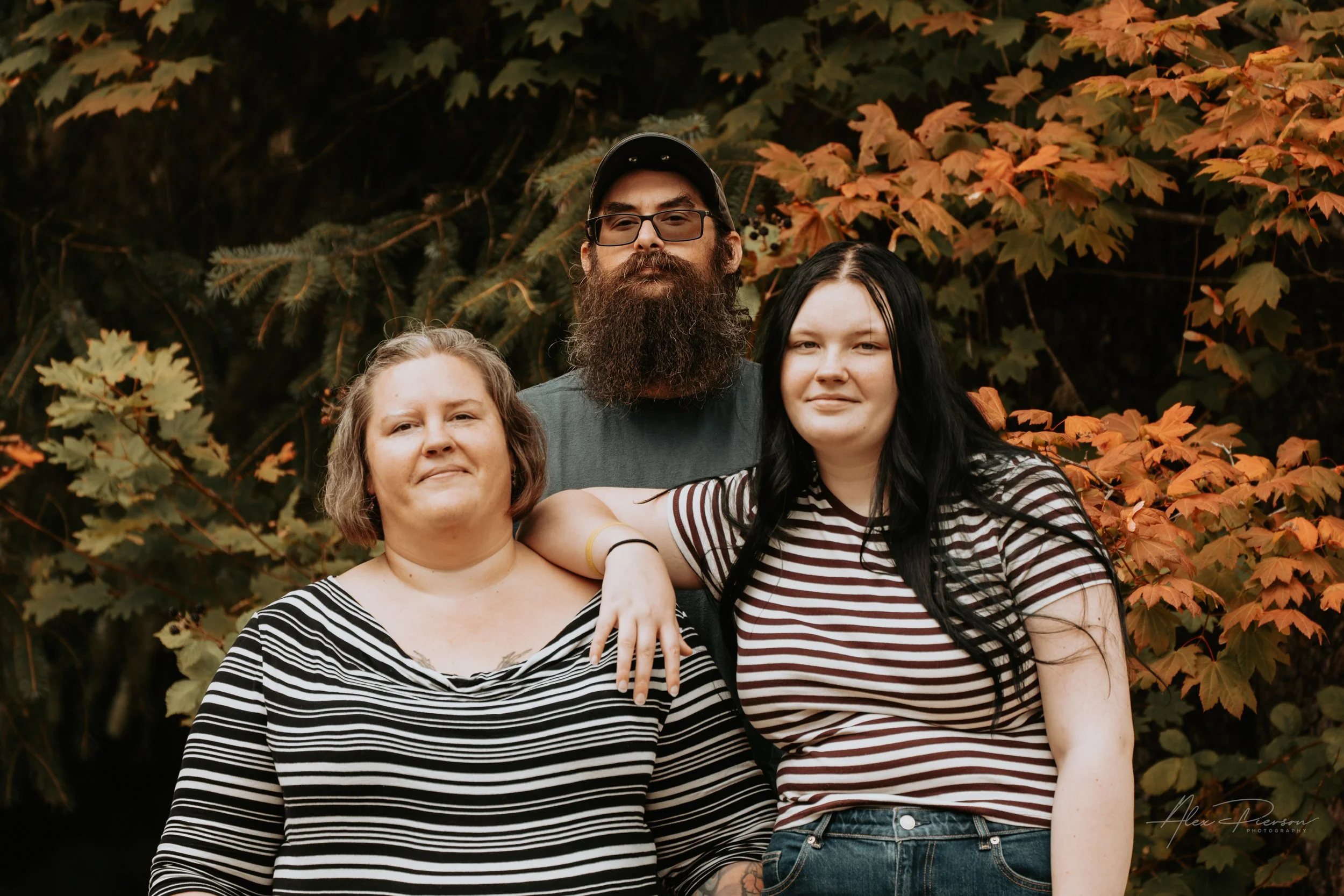 Mother and Daughter and Father posing for the camera during an autumn family photoshoot in their backyard in Montesano, WA- – Pacific Northwest lifestyle family and children's photography.
