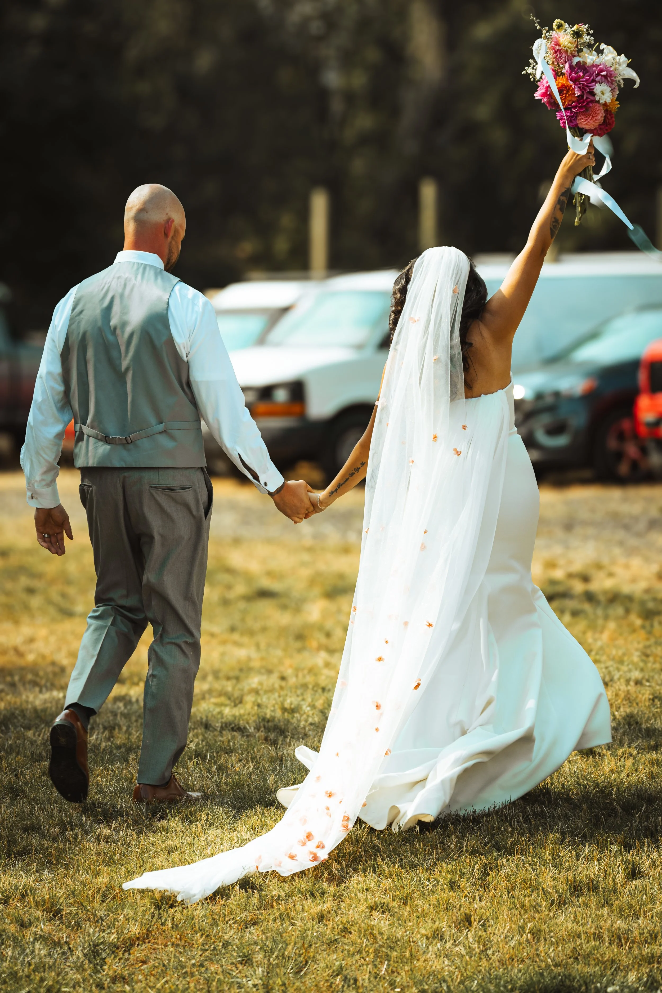bride and groom walking away while holding hands during their wedding in Olympia, WA