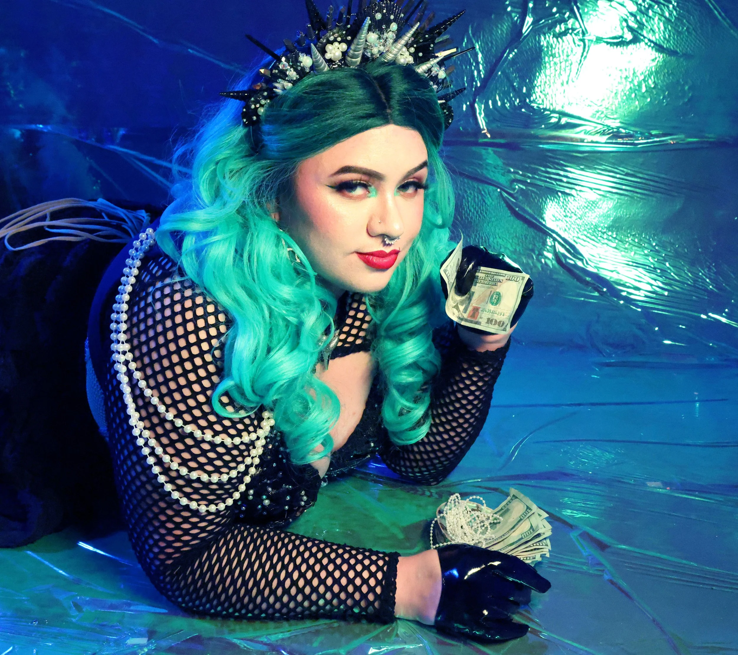 MerDomina shows off the spoils of Her financial domination with a shell full of cash, in turquoise hair & a handmade shell crown