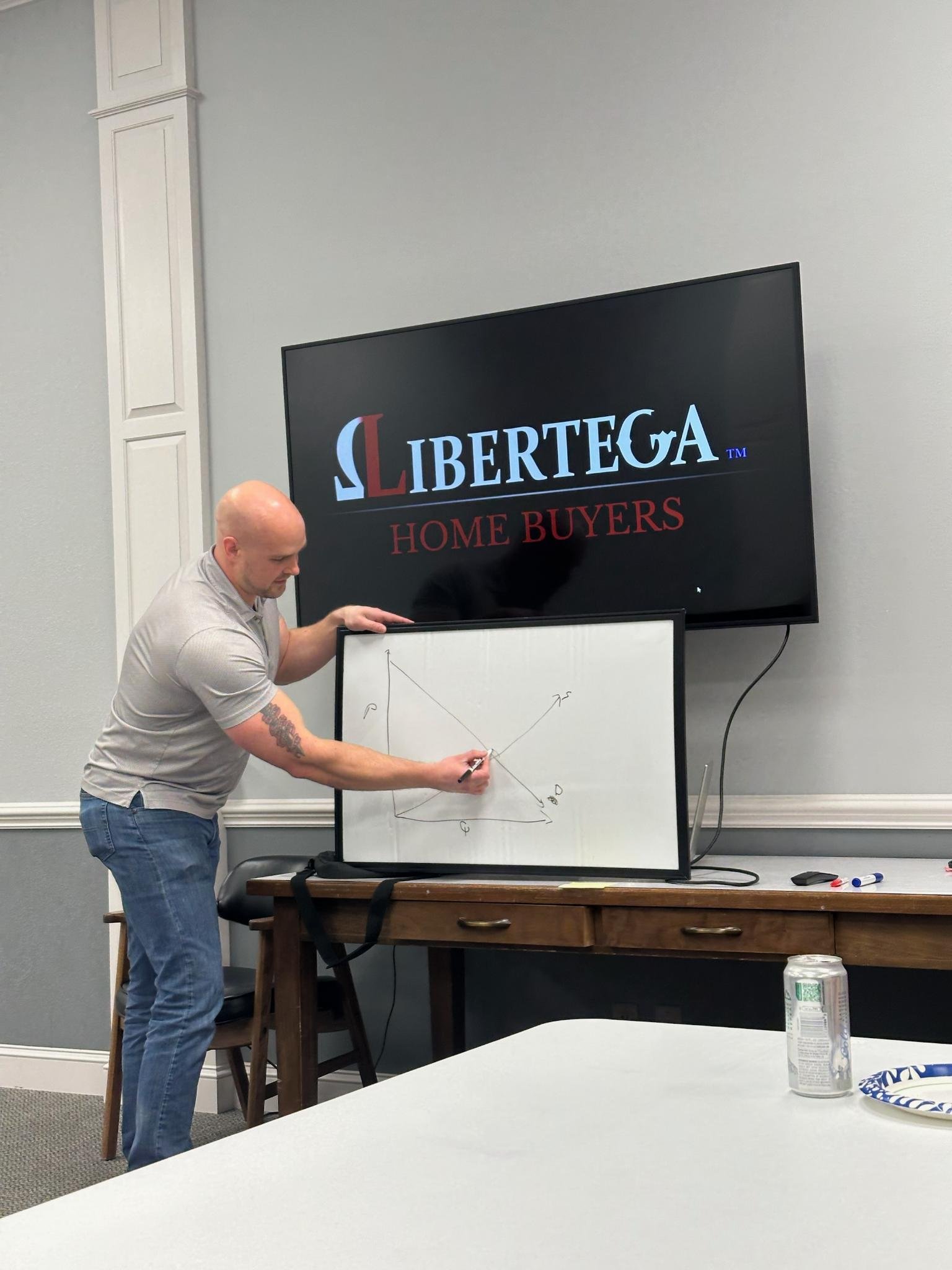Daniel Rhyan presenting a diagram on a whiteboard with "Libertega Home Buyers" on the monitor during a Real Estate Visonaires Meetup in Casper,WY.